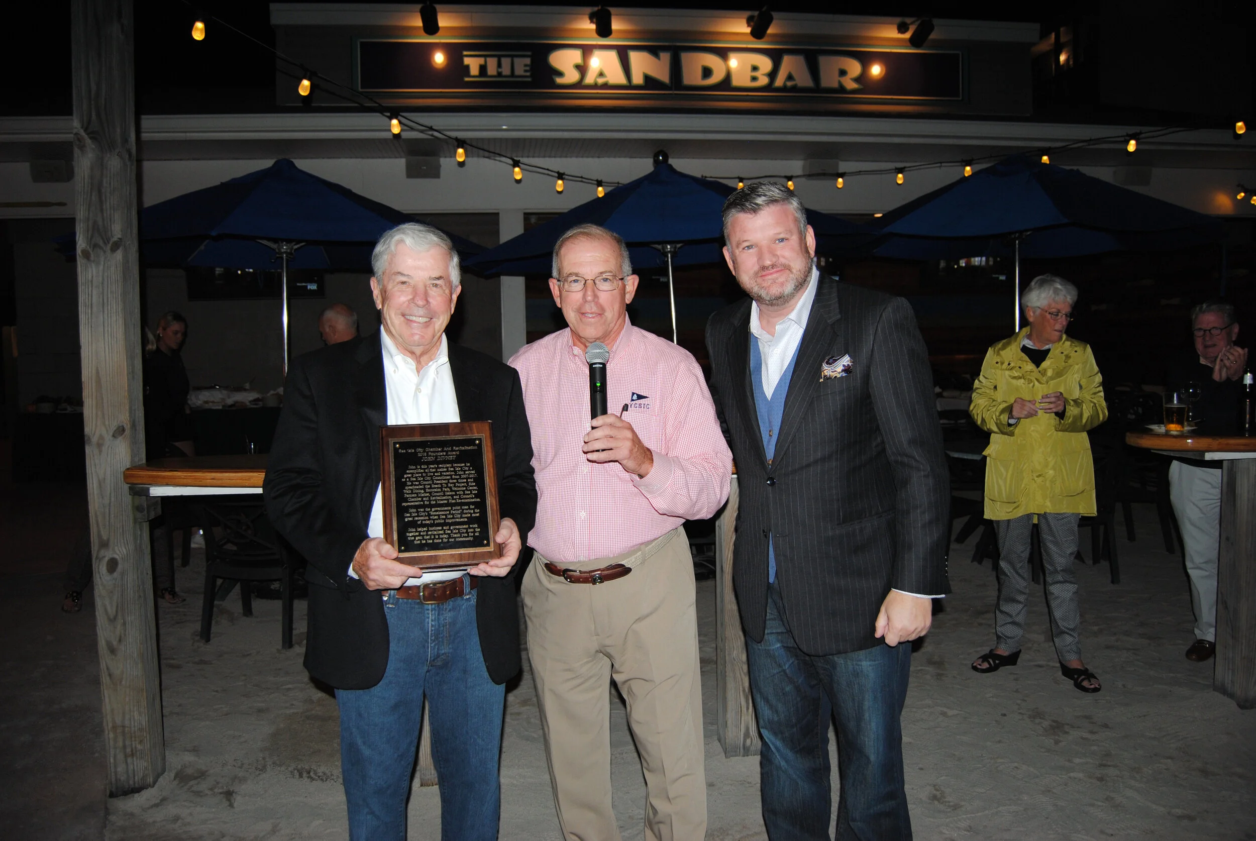 John Divney received the Founders Award from Bill Buchanan and Chris Glancey at the 2018 Around the World Social.