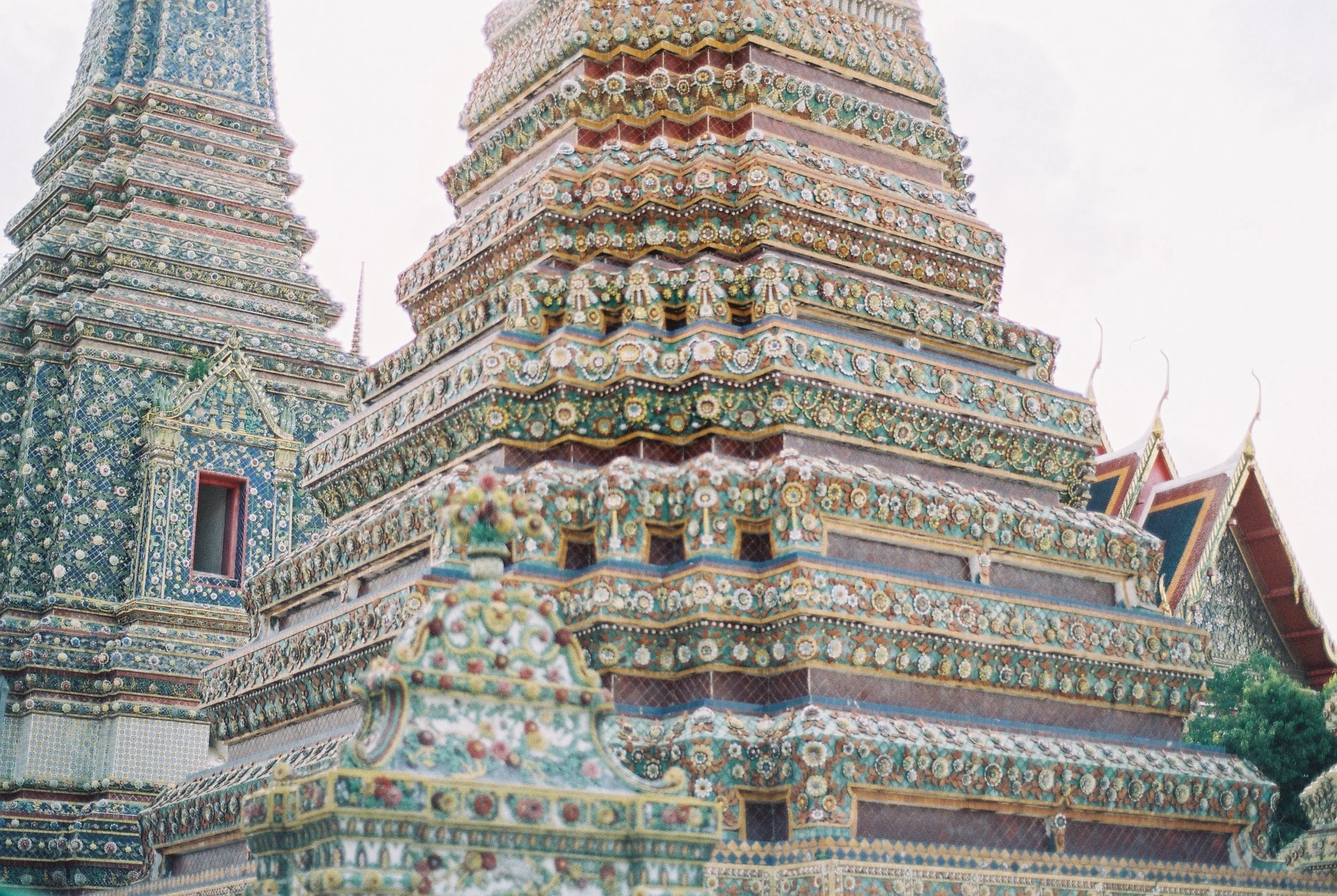 Close-up of a decorated temple with intricate patterned tiers and ornate details, likely a Buddhist temple in Thailand.