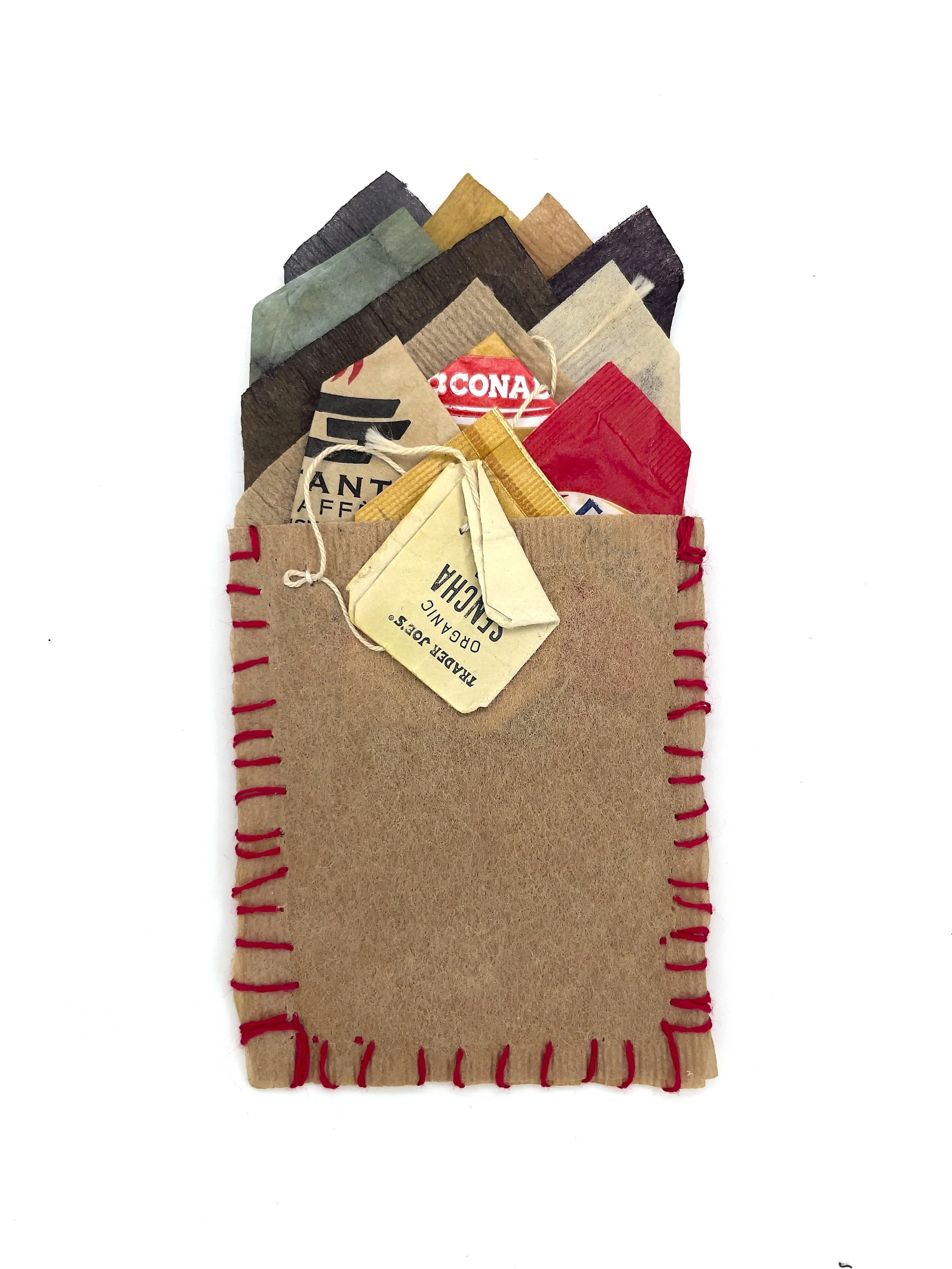 Marking Time 80 , 2023, Italian sugar packets, paper, thread, dyed teabags, 5.5 x 3.25 inches (unframed), 11.25 x 9.25 inches (framed), $475. (framed)