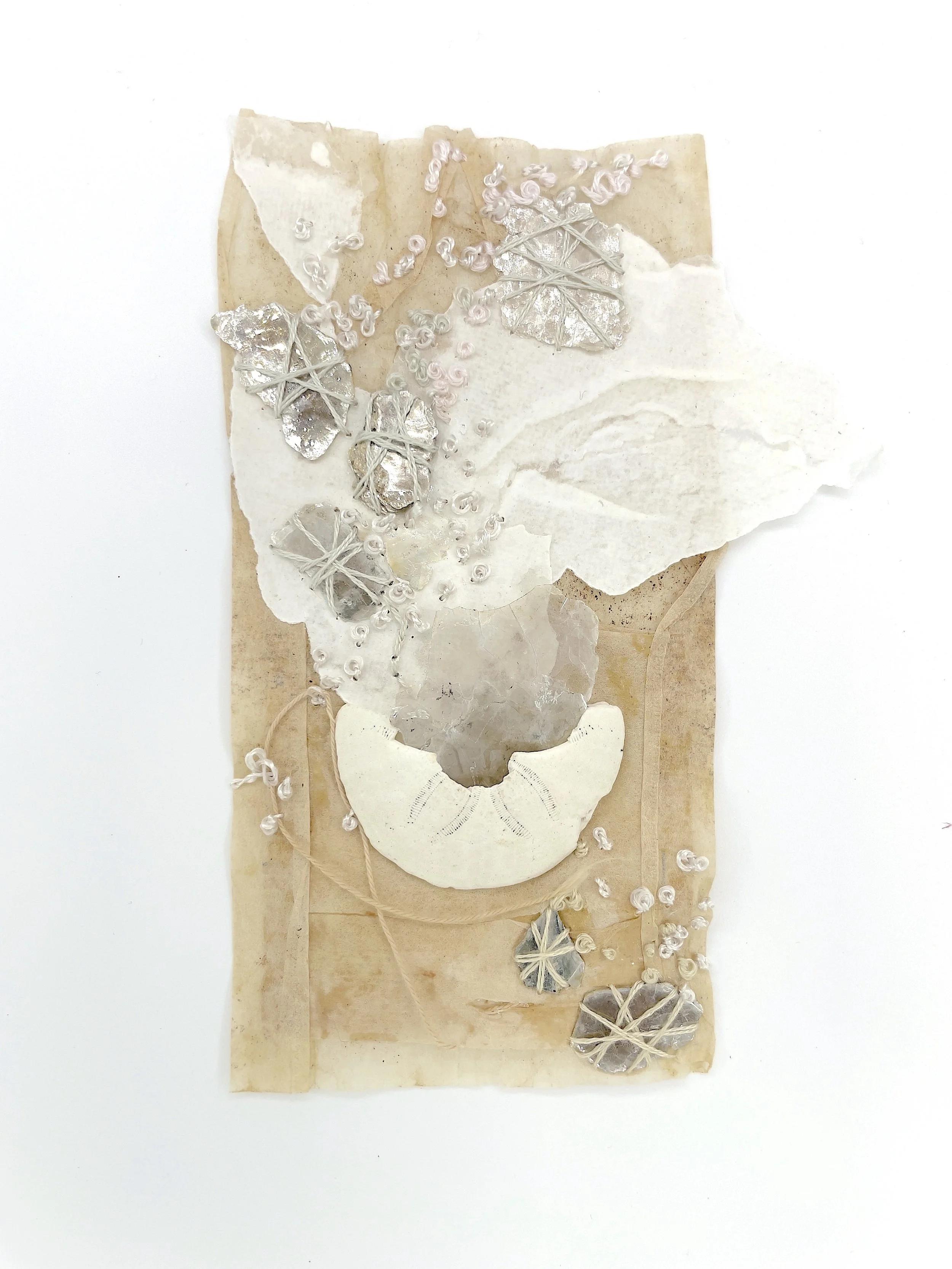Marking Time 85 , 2023, mica flakes, sand dollar, handmade paper, thread, teabag, 5.5 x 3.25 inches (unframed), 11.25 x 9.25 inches (framed), $475. (framed)