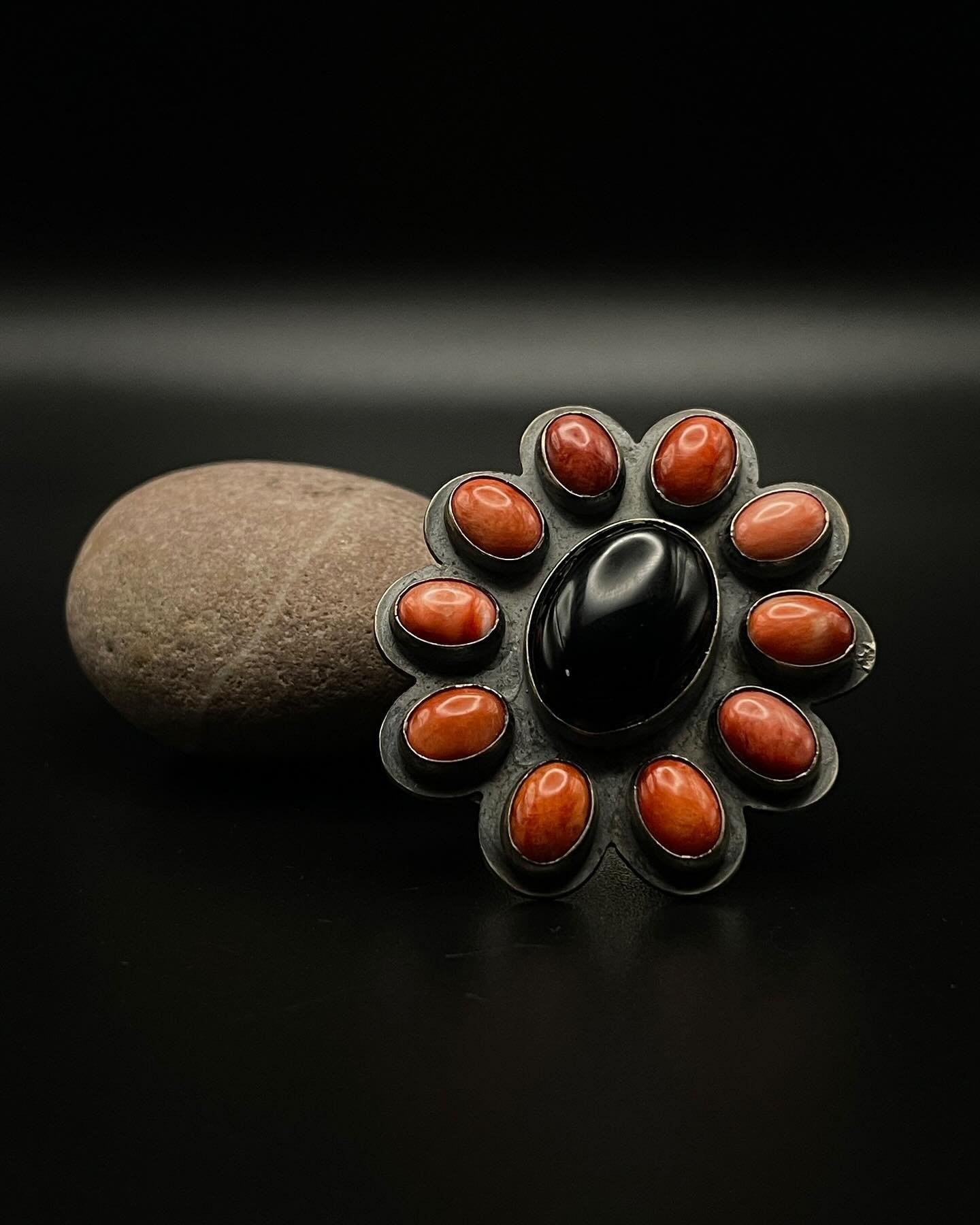 Ring: Gilbert Platero Onyx and Spiny Oyster
An impressive sterling ring formed by the highly collectable artist Gilbert Platero. It has a central onyx cabochon and spiny oyster shell clusters that create a heavy metal shield.

The weight, the gauge, 