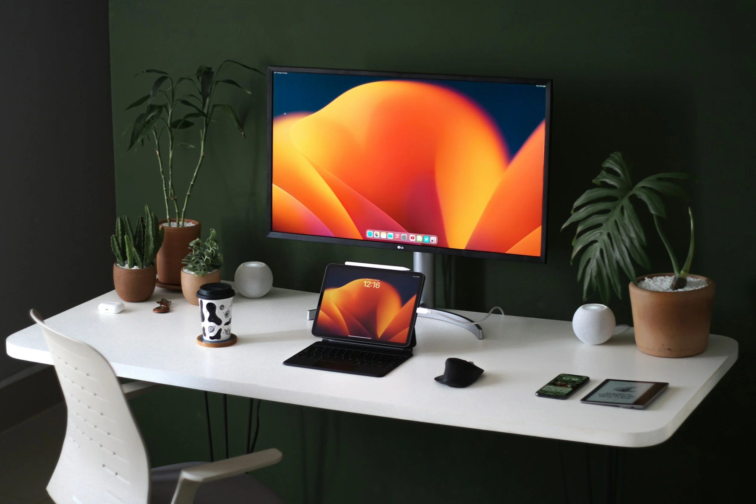 desk setup. white table desk, an iPad with a keyboard centered, with a larger monitor connected above it also centered.