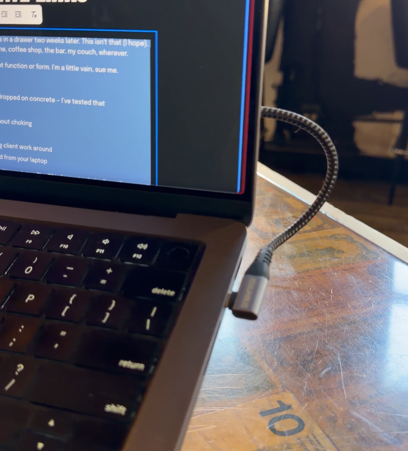 Image of a laptop, zoomed into a usb c port with a right angle cable plugged in