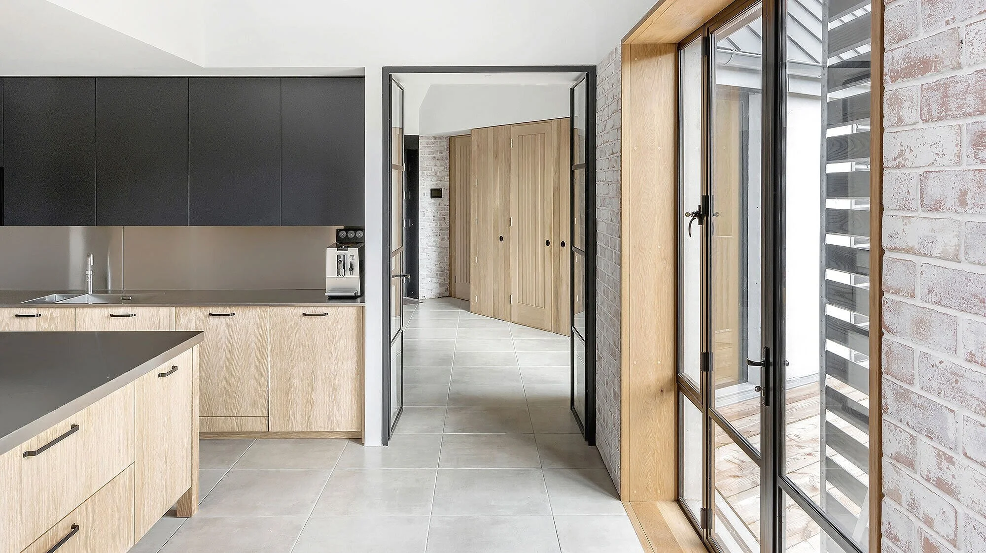 Shaker &amp; May - The Long House by Neil Choudhury ArchitectsPhotography Pete HelmeThrough the large blackened steel window frames, the room is bright, calm and was shot using the natural light available.