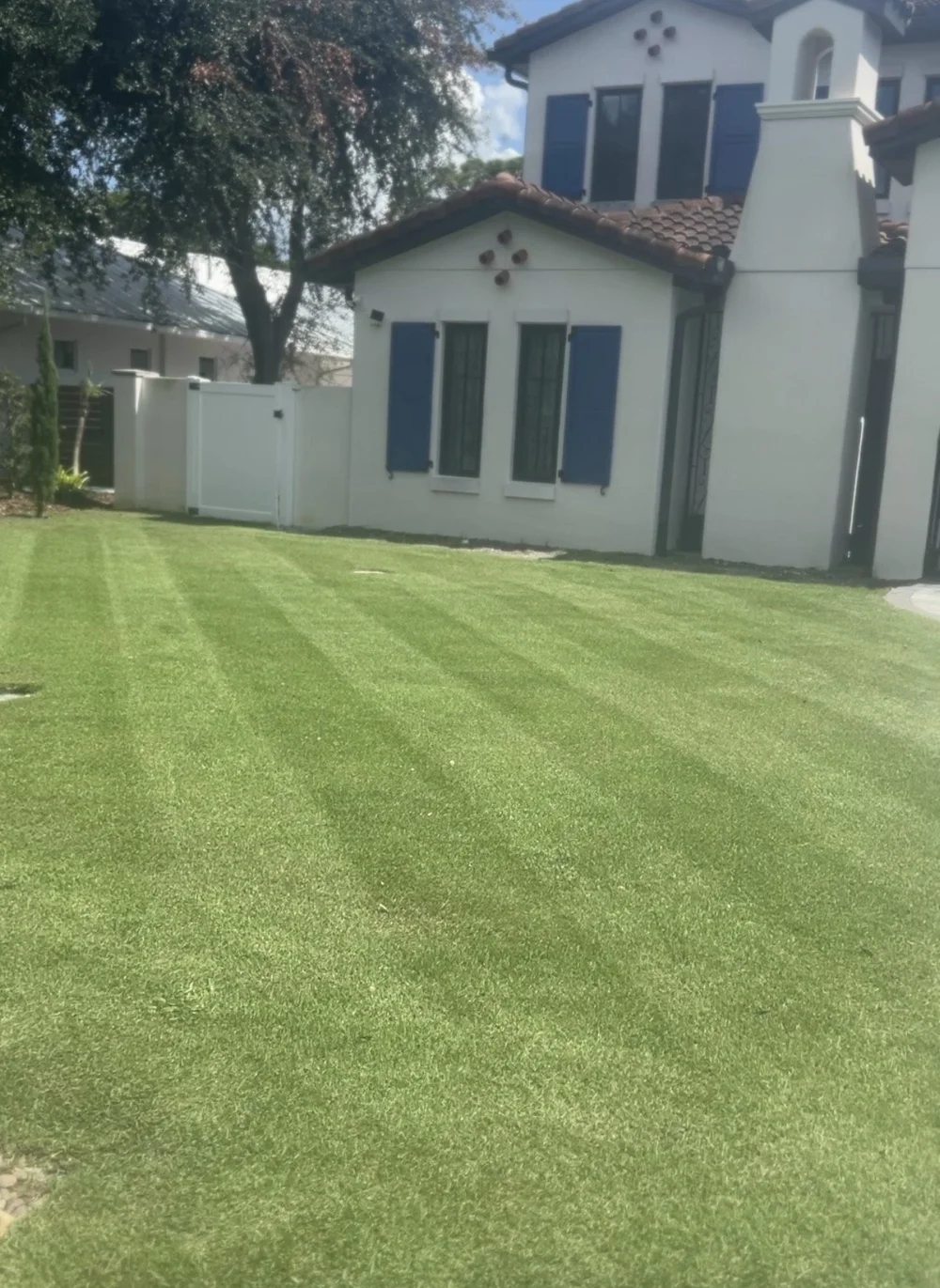 Level, tightly striped zoysia lawn beside a Spanish-style home in Central Florida
