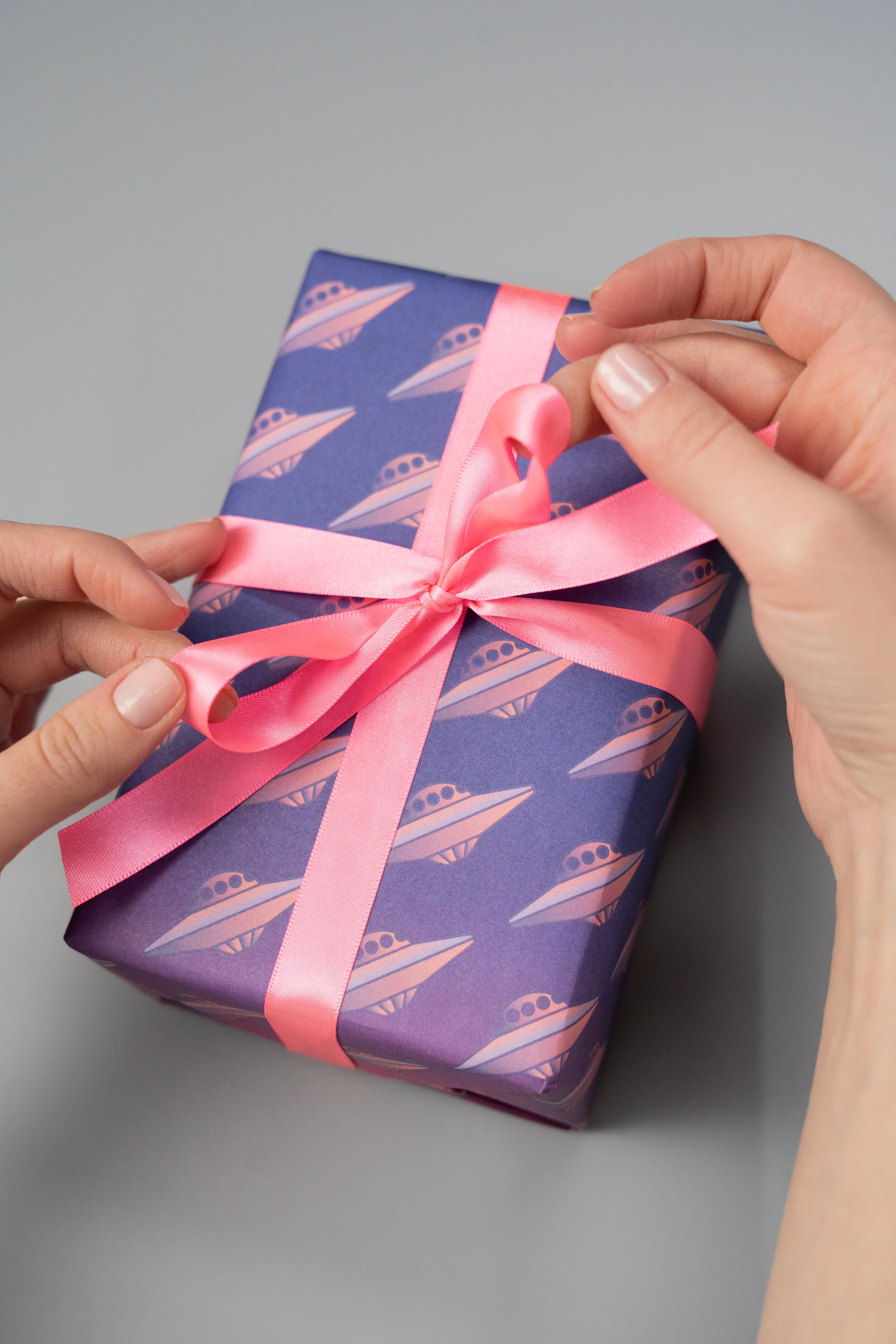 Gift wrapped in fun paper and pink ribbon, ready for its recipient.