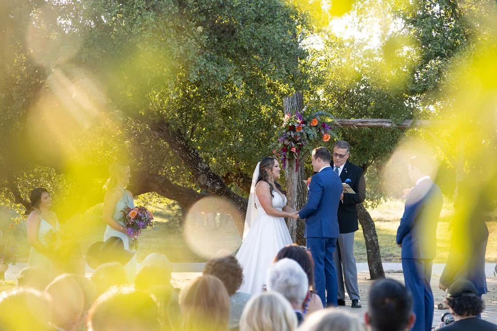 Wedding ceremony in the big oak trees at Sparrow Creek Ranch for a september wedding in north texas.