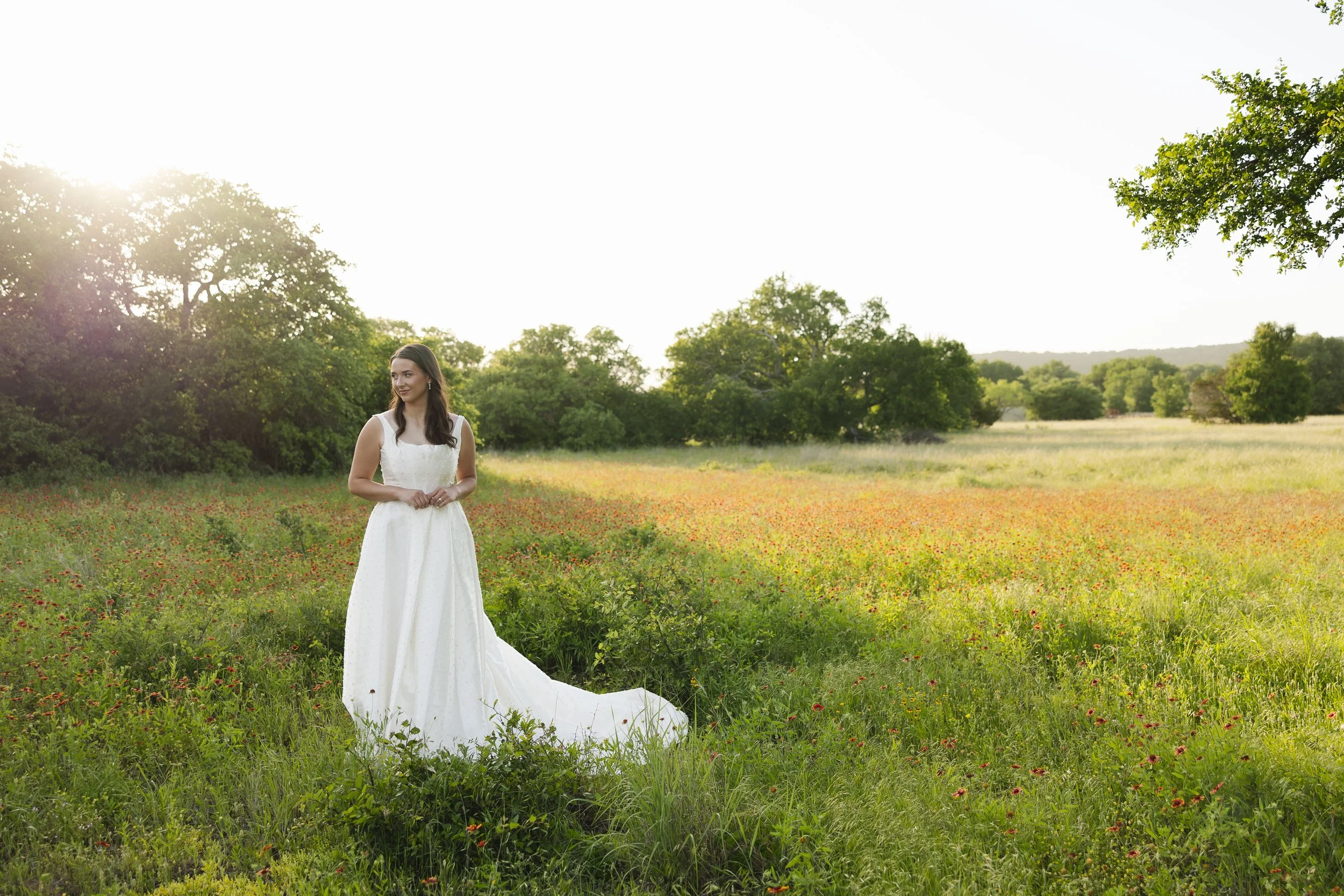 Bride standing in a field of wildflowers at her North Texas wedding Venue.