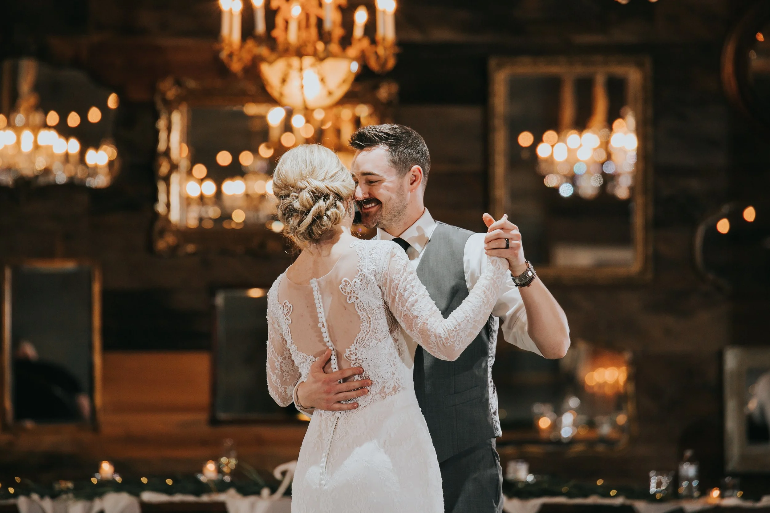Romantic wedding for winter bride with sleeved gown and chandeliers at the reception.
