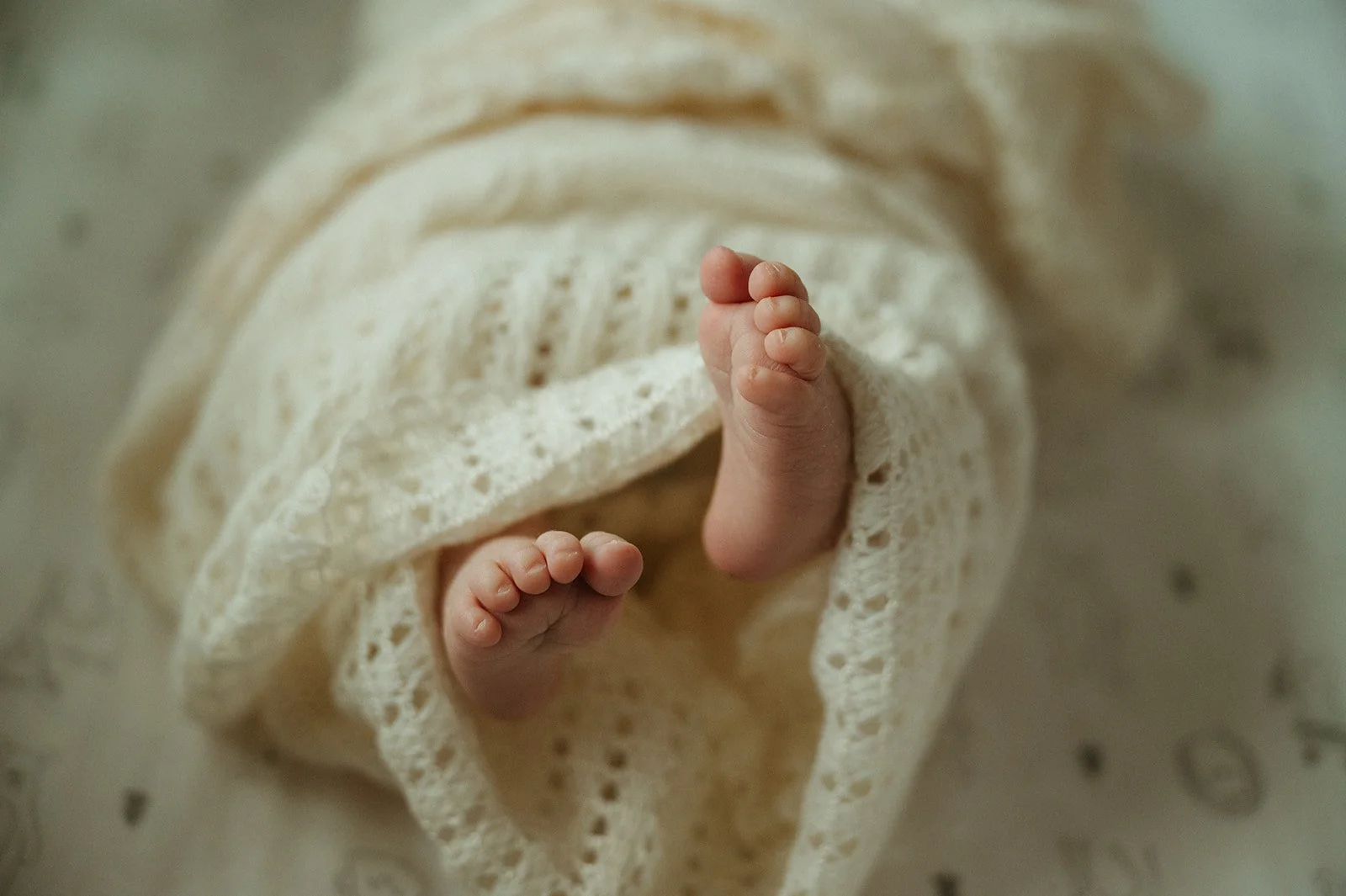 Modern wooden building beside a calm lake with rolling hills and mountains in the background during sunrise or sunset.