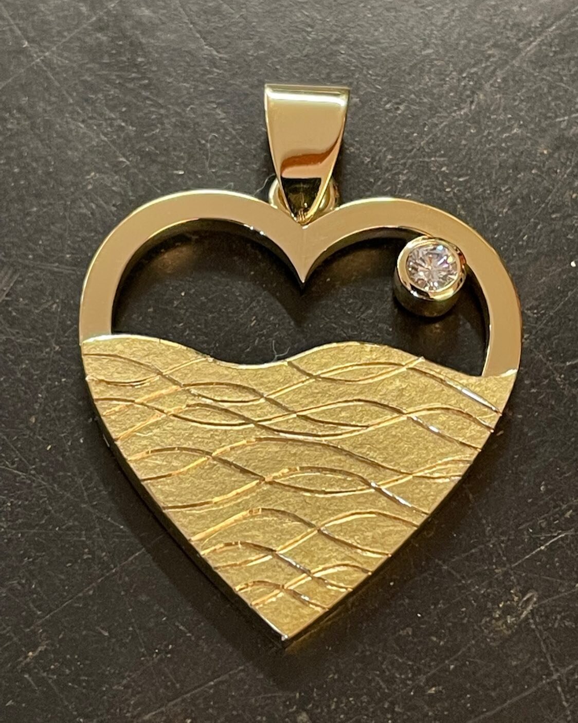 Moon over the waves pendant. Made from a 22ct wedding ring of a recently deceased husband amalgamated with an 18ct ring belonging to his widow.
A memory of a happy time.#sentimental #sentimentaljewellery #18ct pendant #heartpendant #handmadeinsuffolk