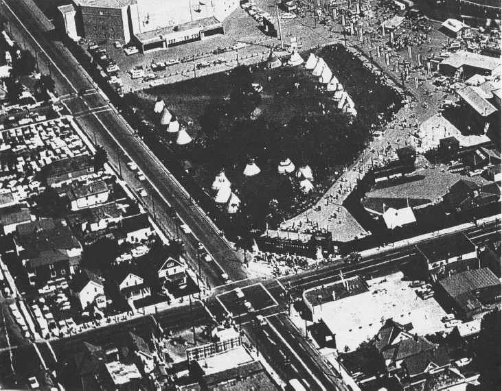  This post-1950 oblique aerial photograph includes the block that was demolished to create the transit terminal in 1974. The gate appears at the SE corner of 17 Avenue and Macleod Trail. To the left, across 17 Avenue from the gate, from right to left