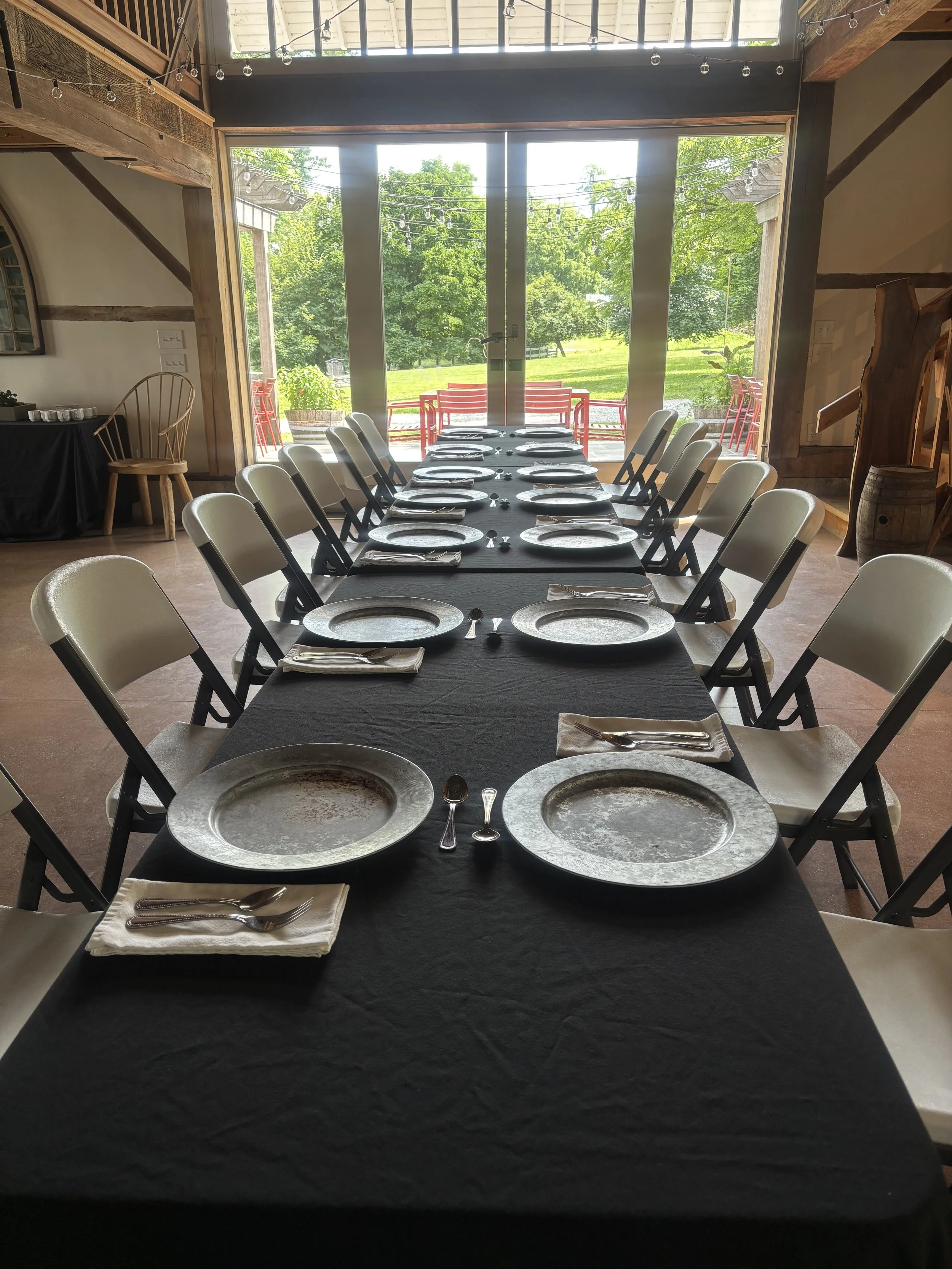 Silver dinner plates on a black tablecloth