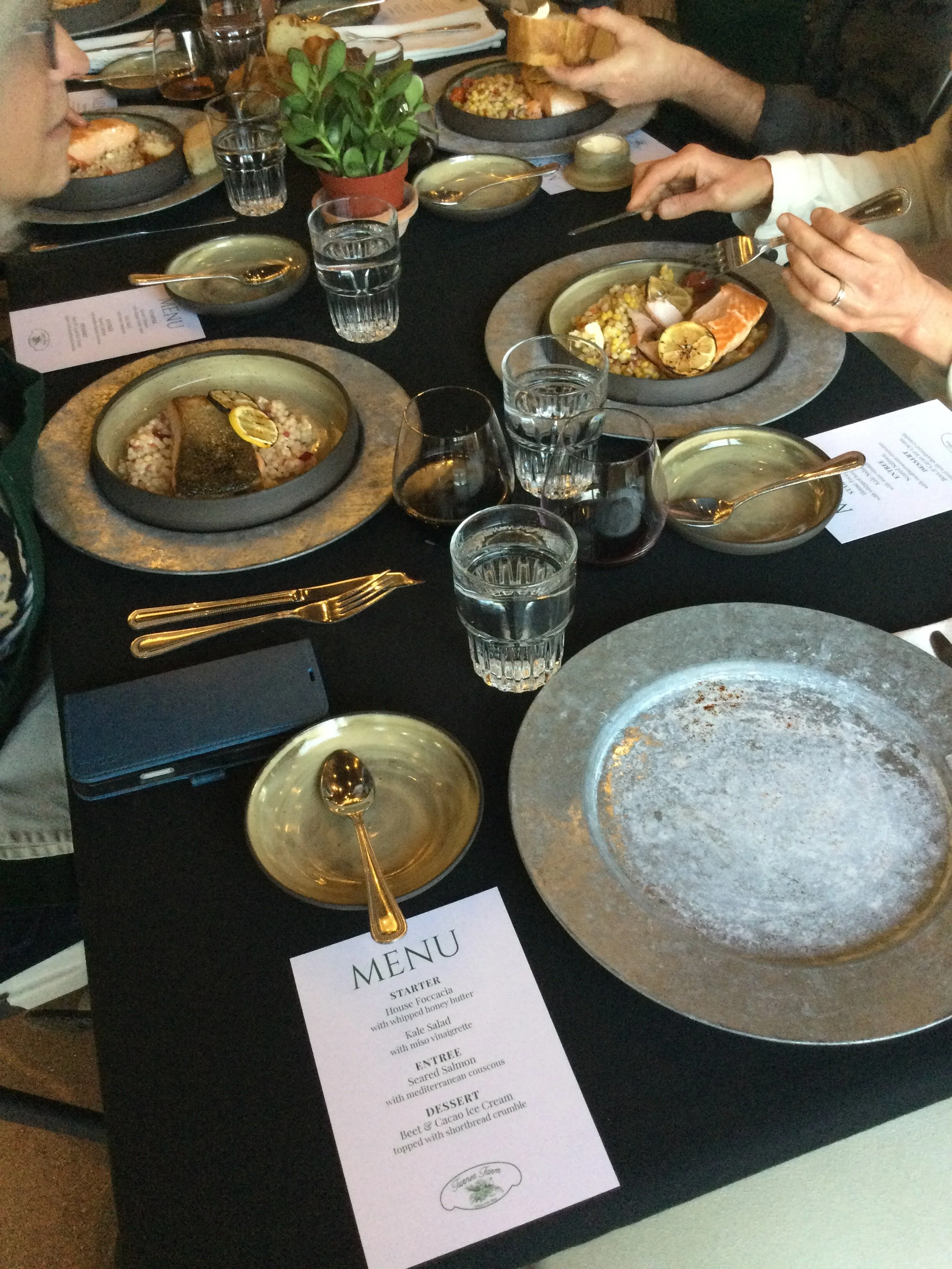 Plates filled with couscous and salmon placed on a black tablecloth