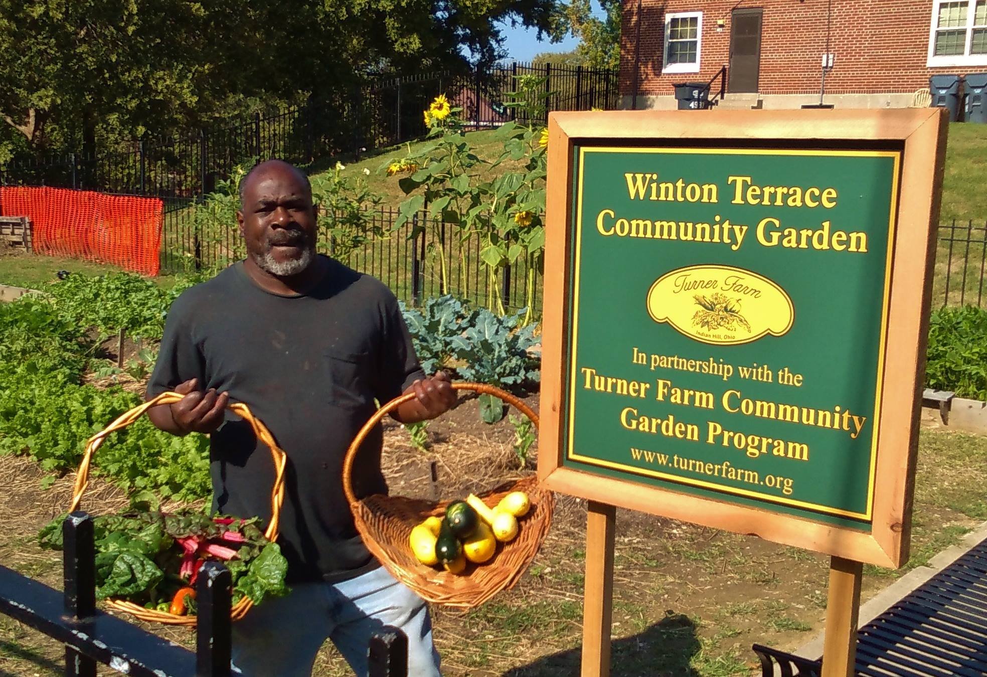 Man holding vegetables at a community garden