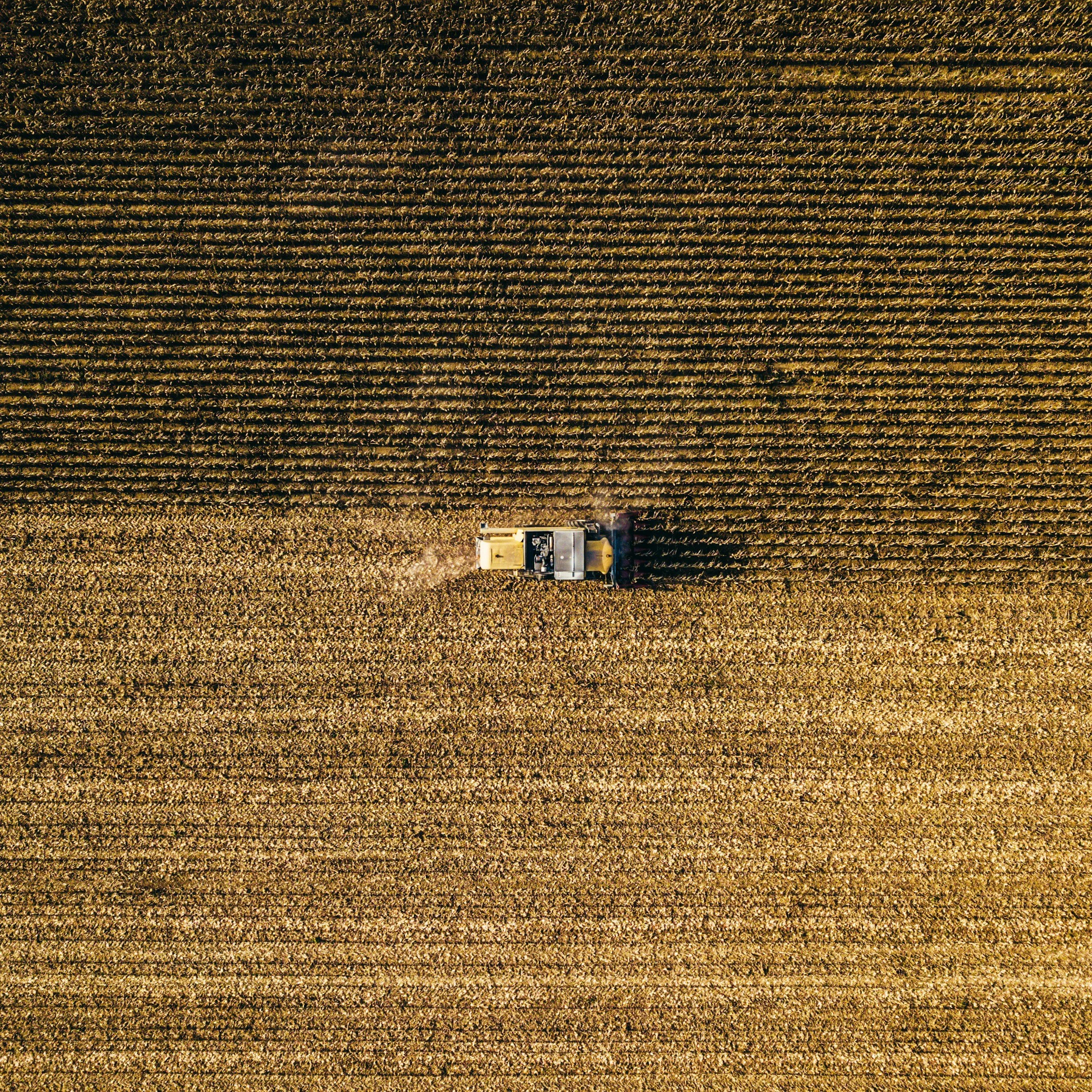 Vista aérea de un tractor trabajando en un campo de cultivo dorado