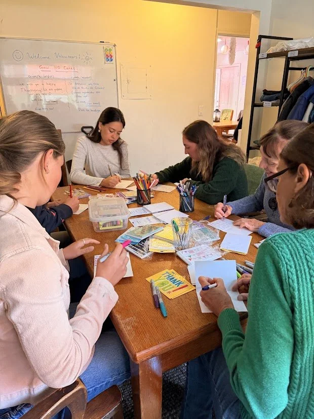Volunteers writing hand-written notes of encouragement