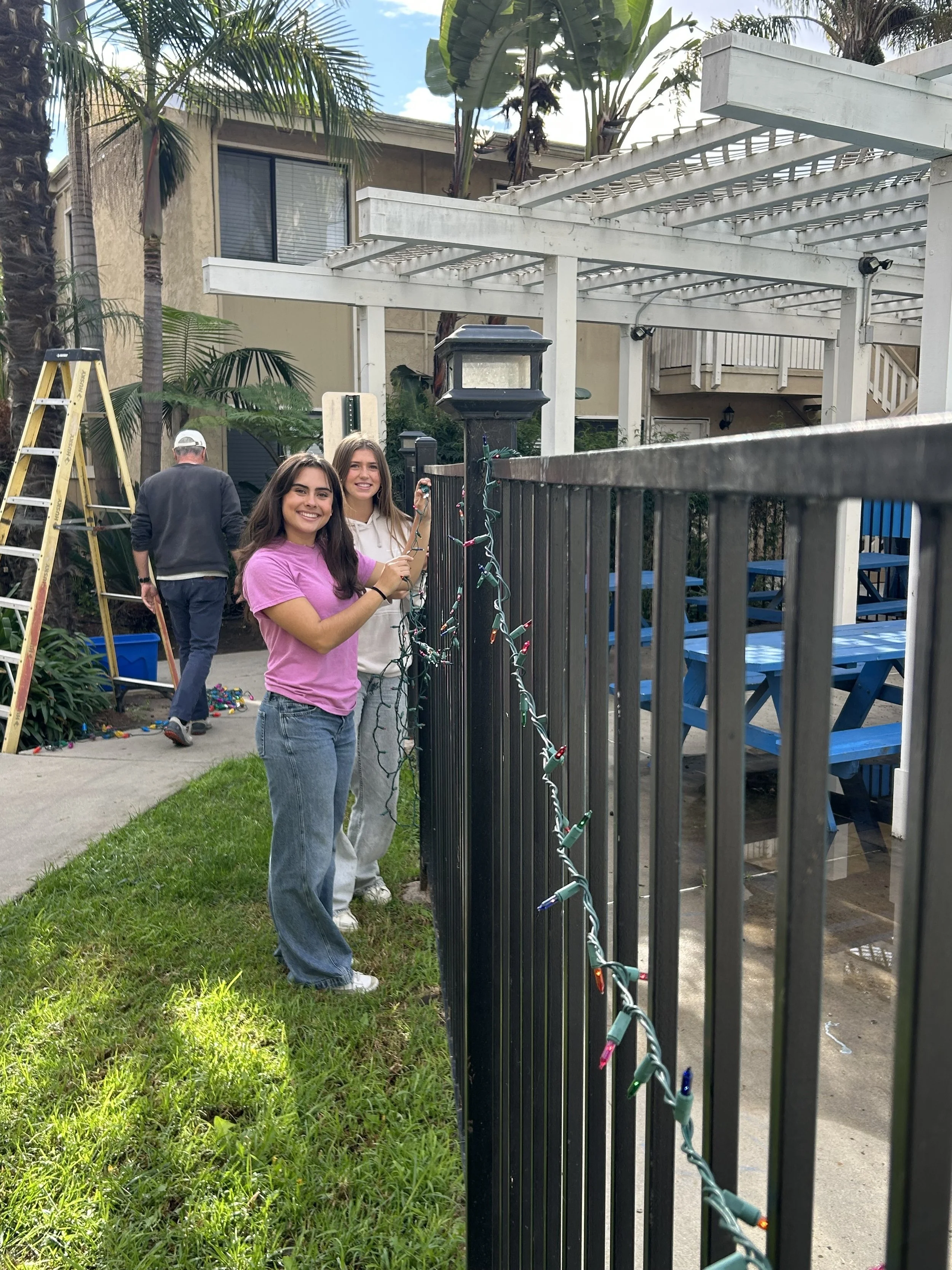 Volunteers hanging lights around the Village