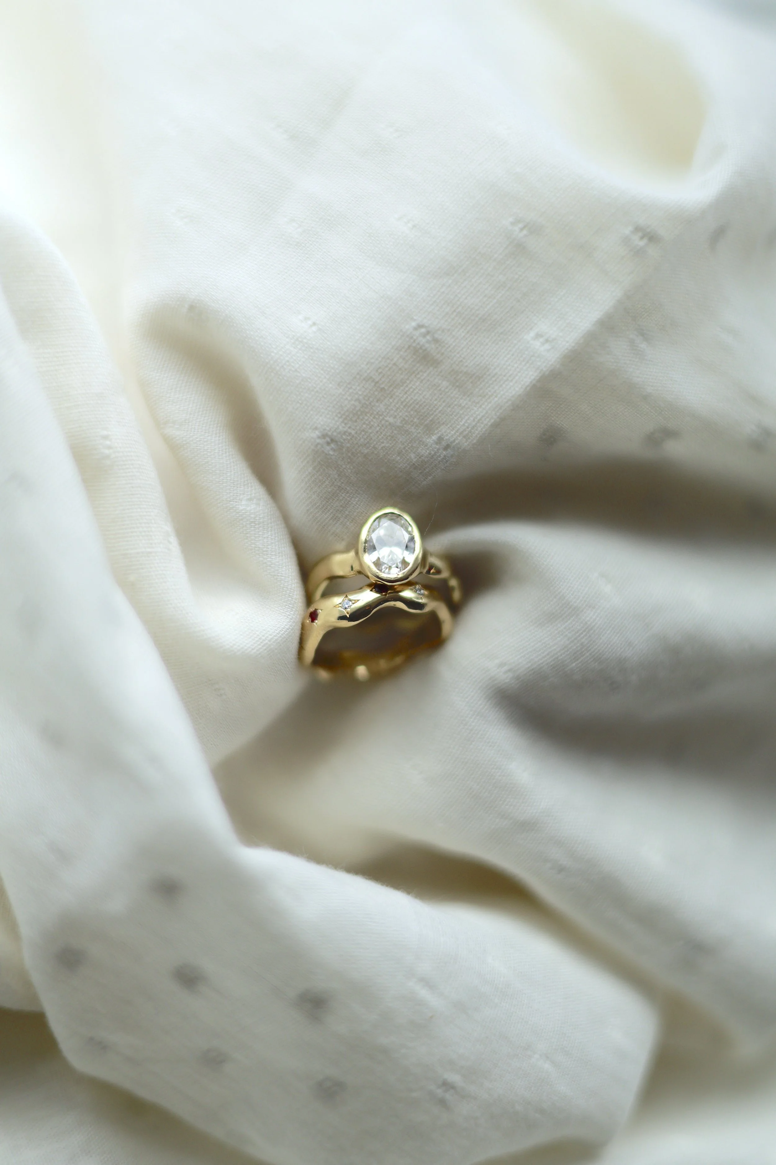 Bezel set lab diamond on a 18ct organic band, with matching wedding band with star set rubies and diamond
