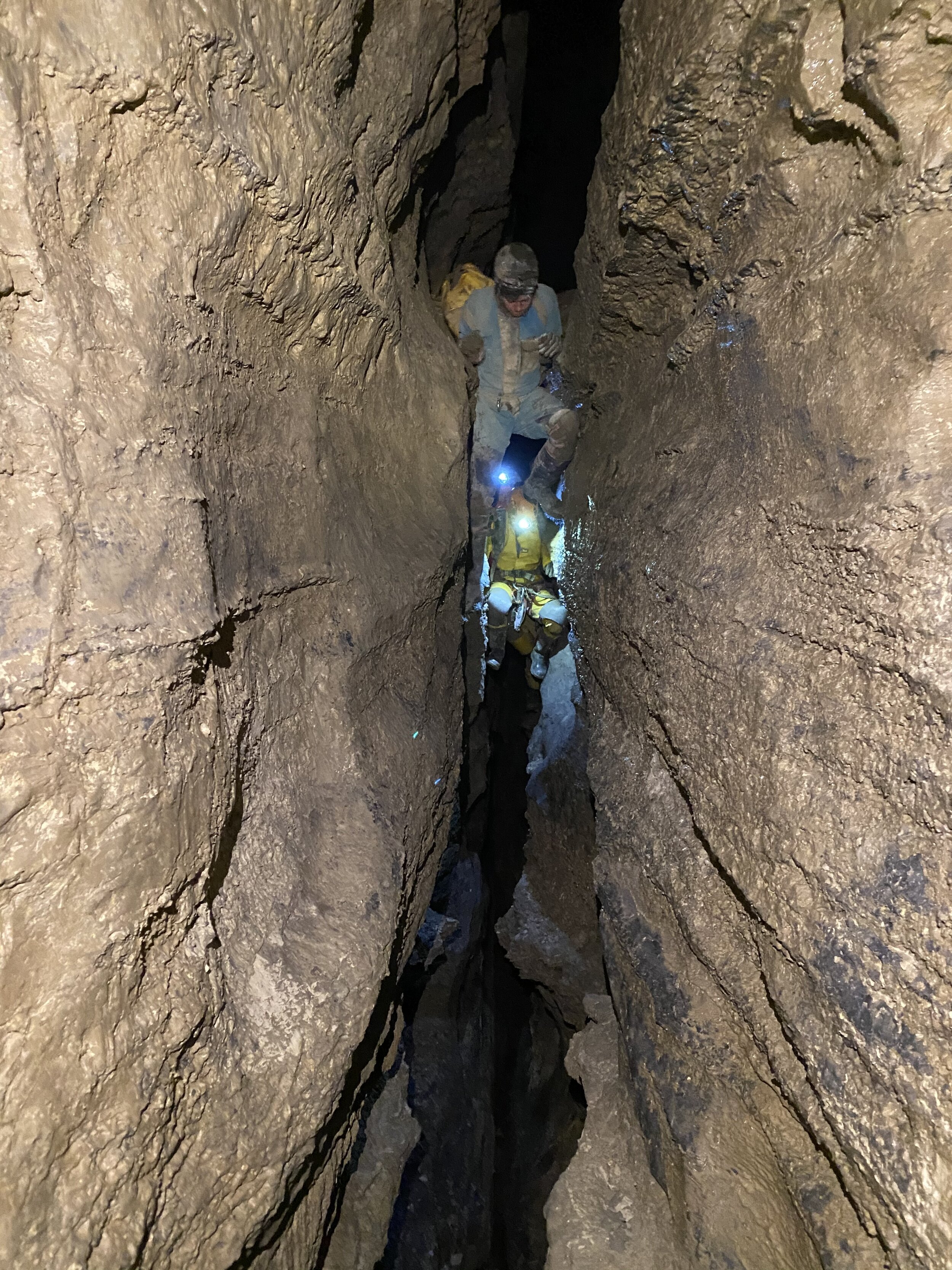 Cavers negotiate the Second Fissure, Castleguard Cave. Photo: C. Stenner 2020