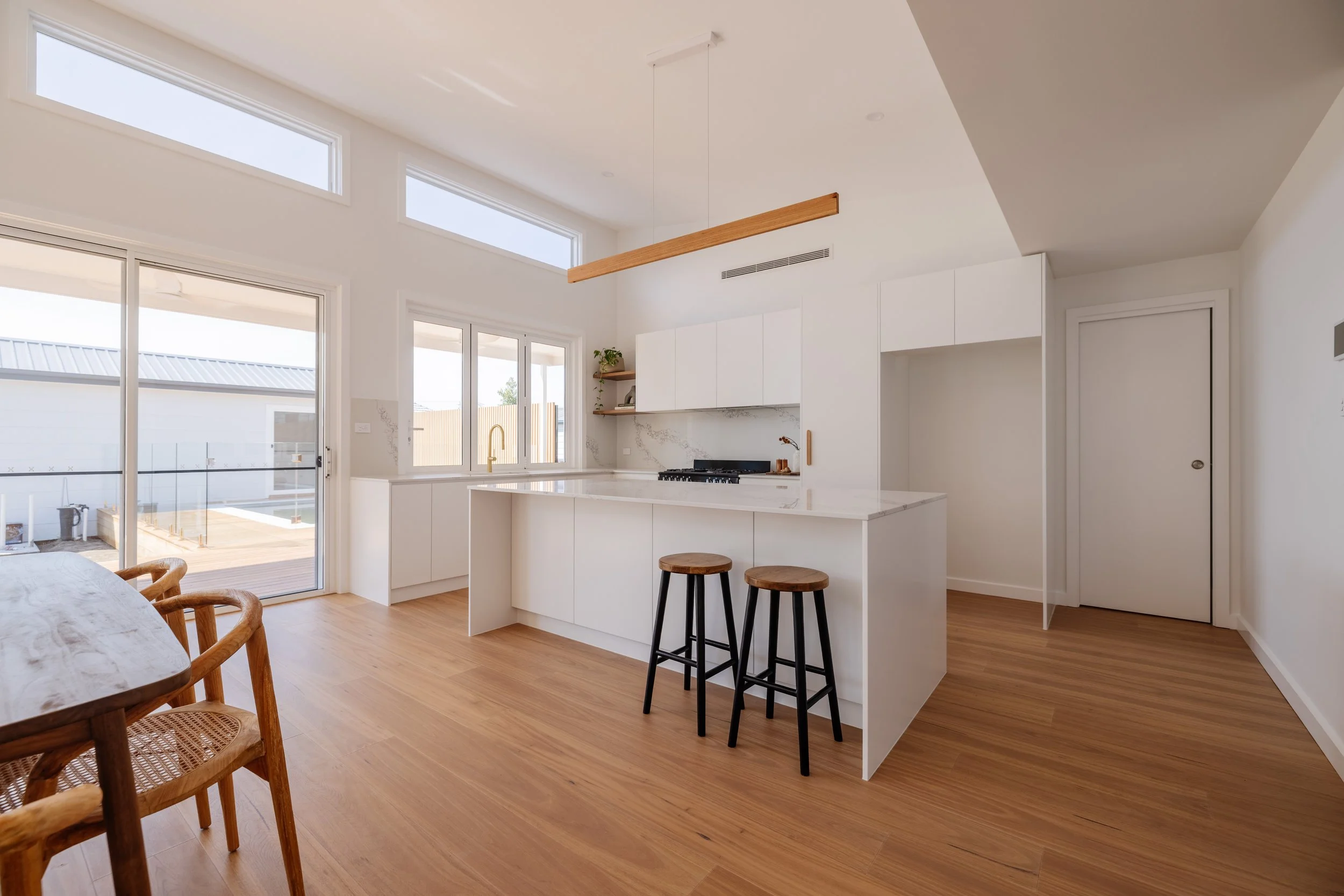 White kitchen renovation in house with large windows