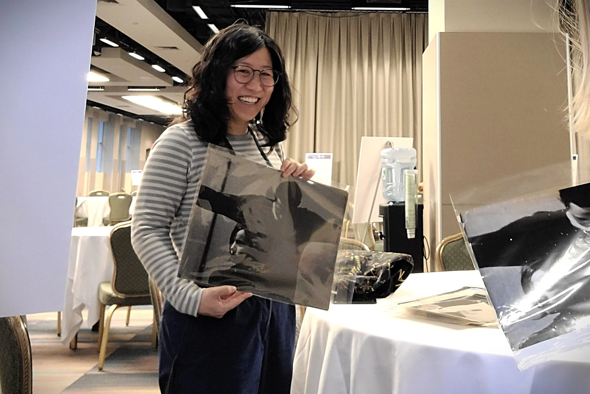 Tate curator Dr. Charmaine Toh studying Zenta Dzividzinska’s vintage prints