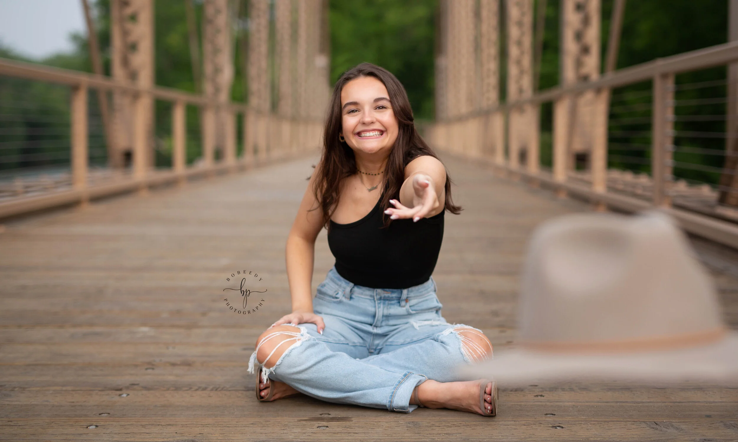 senior girl photo session on minneapolis bridge throwing hat bobeedy photography maple grove senior photographer