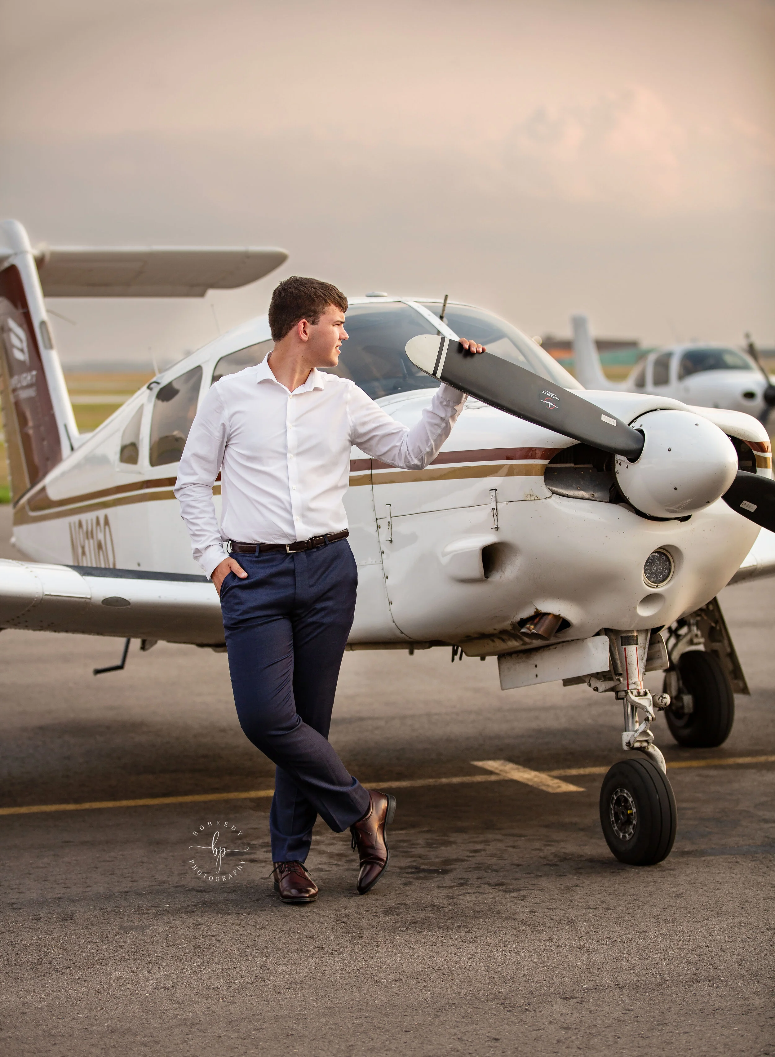 senior guy pose with plane photo session flying cloud airport maple grove senior photographer