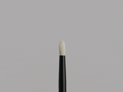 Close-up of a makeup brush with a black handle and white bristles on a gray background.