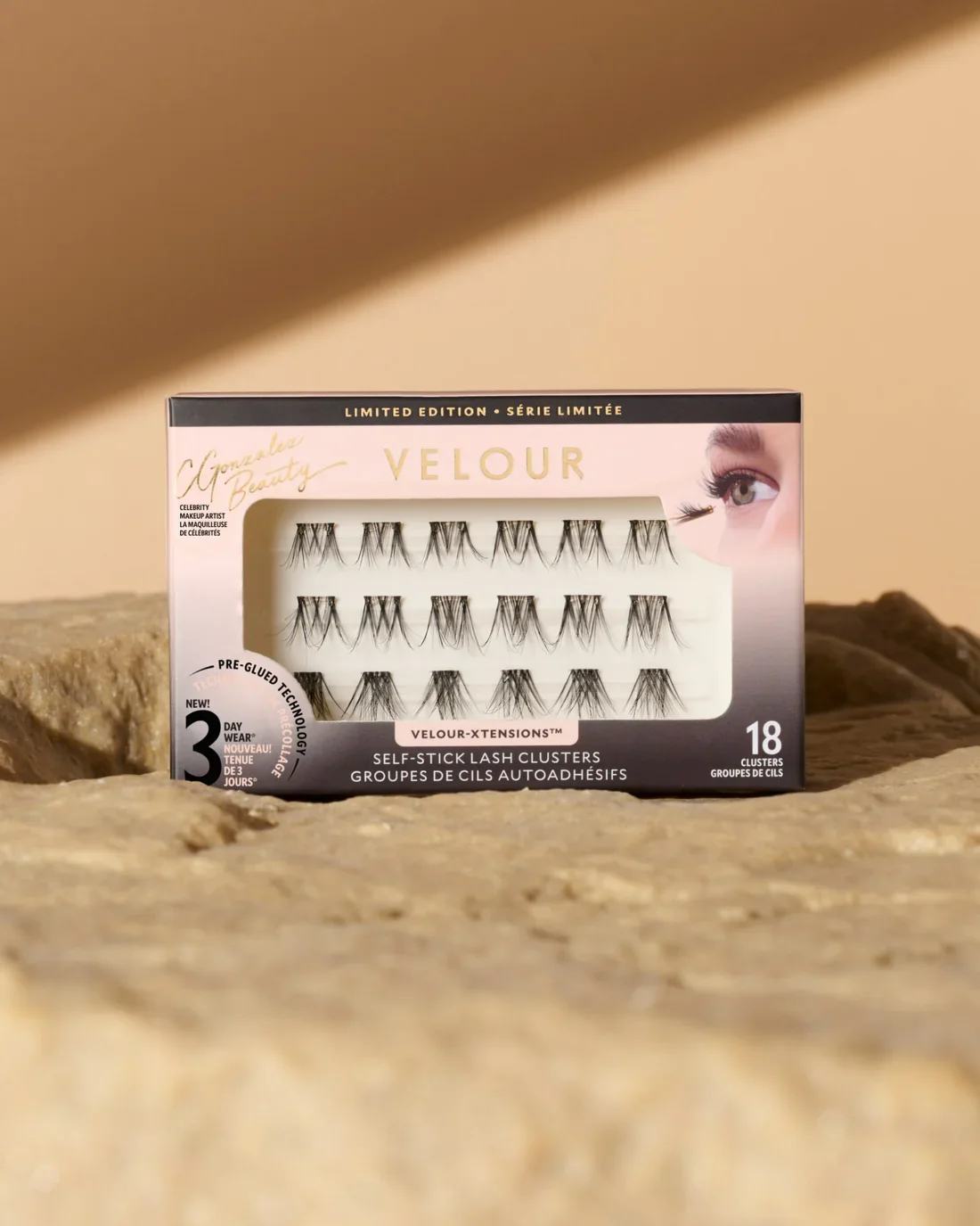 Box of Velour self-adhesive false eyelashes with 18 lash clusters, placed on a textured beige surface.