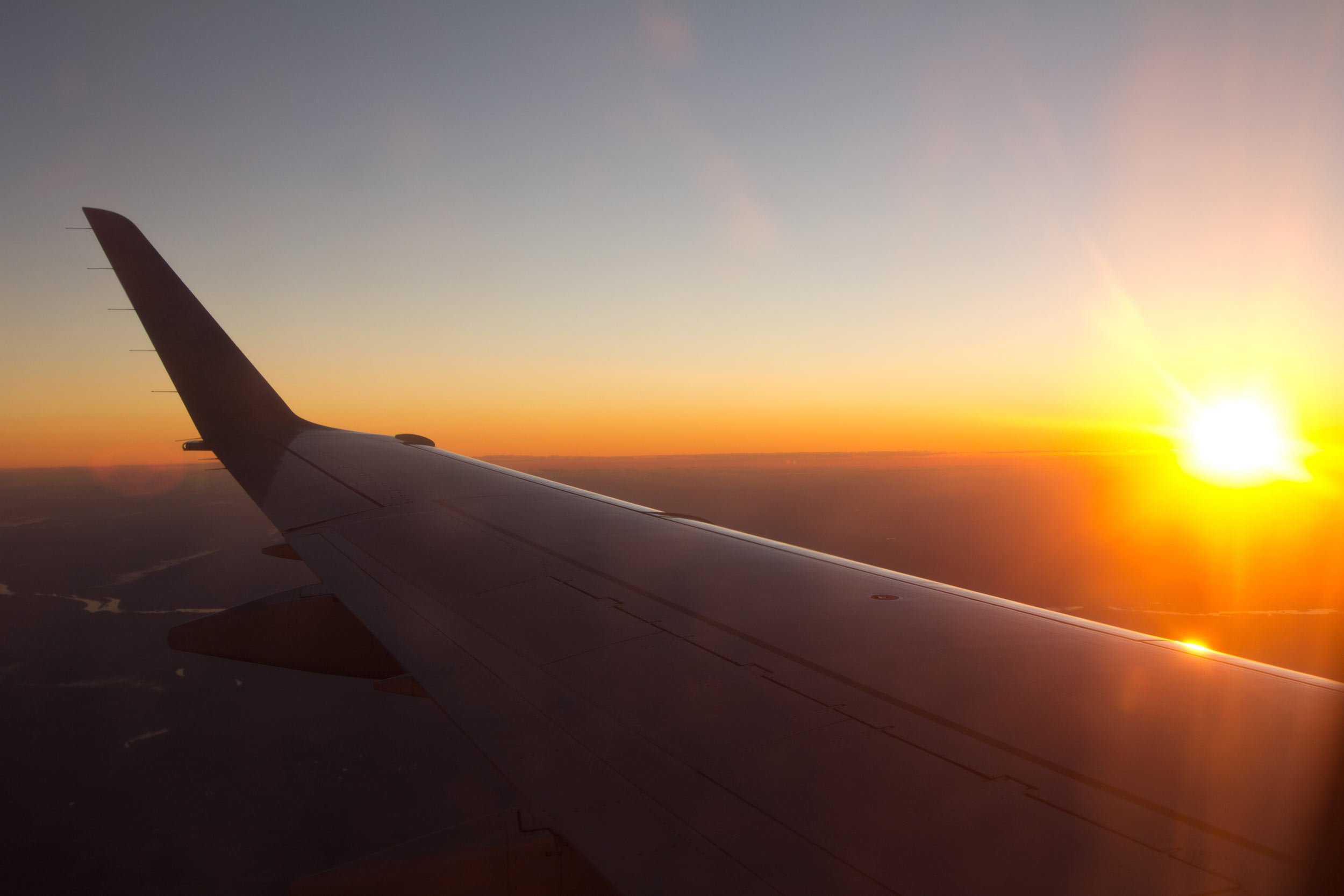 airplane-flying-into-a-sunrise