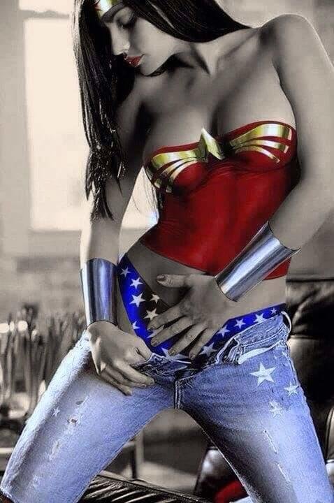A woman wearing a Wonder Woman-inspired outfit with a red and gold top, silver cuffs, and star-spangled jeans, standing indoors.