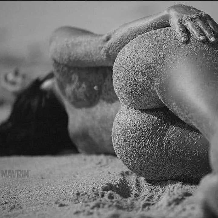 Close-up of a sand sculpture of a reclining woman made from sand on a beach
