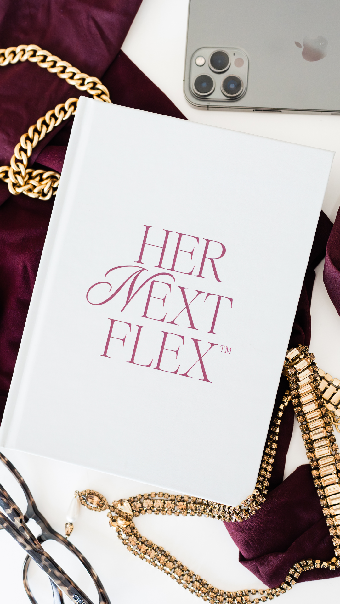 Her Next Flex™ branded journal styled with gold jewelry and leopard-print accents in a luxury flat lay brand photo