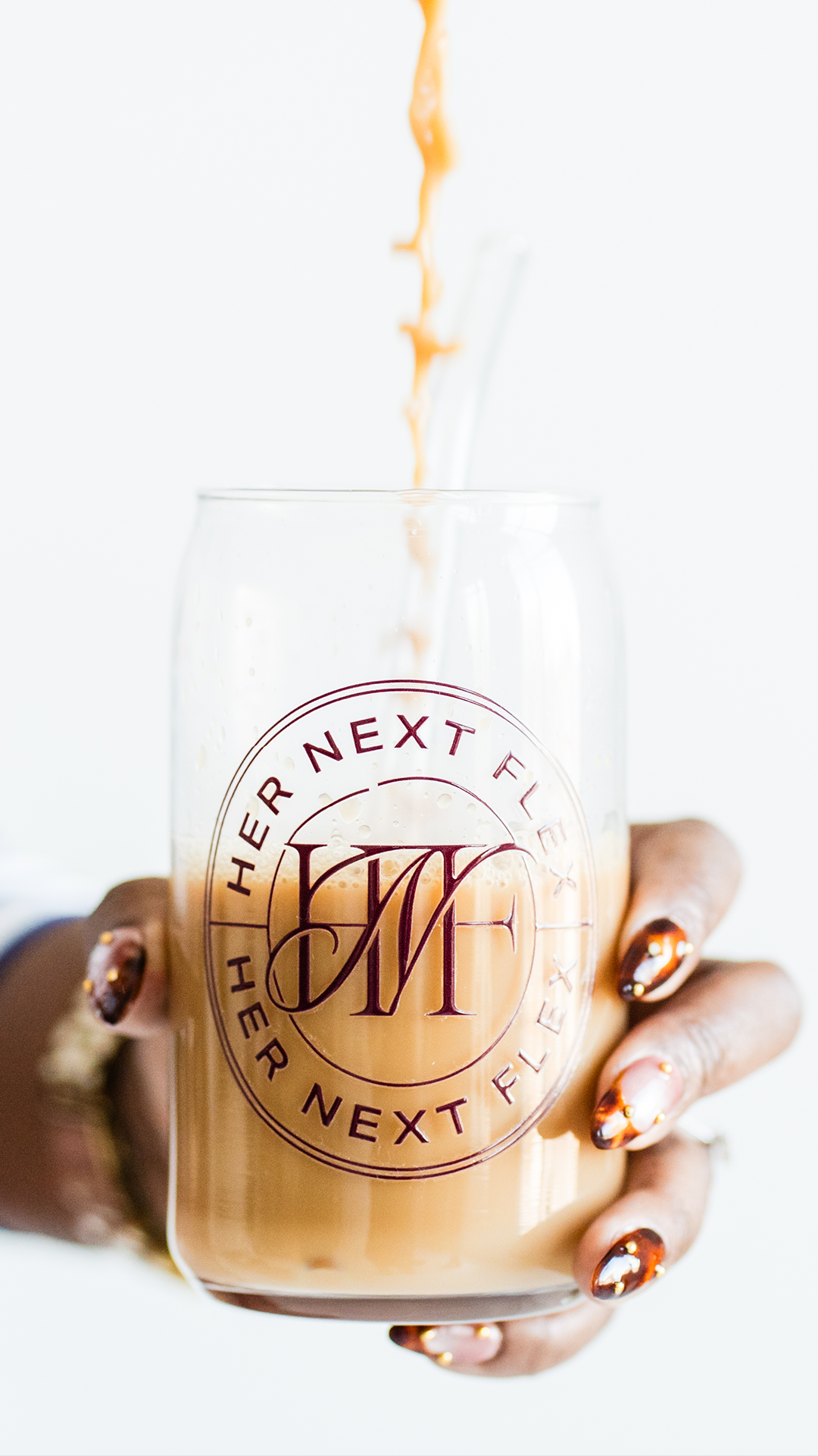 Her Next Flex branded glass mug with circular logo badge, product mockup for a coach and podcaster's merch line