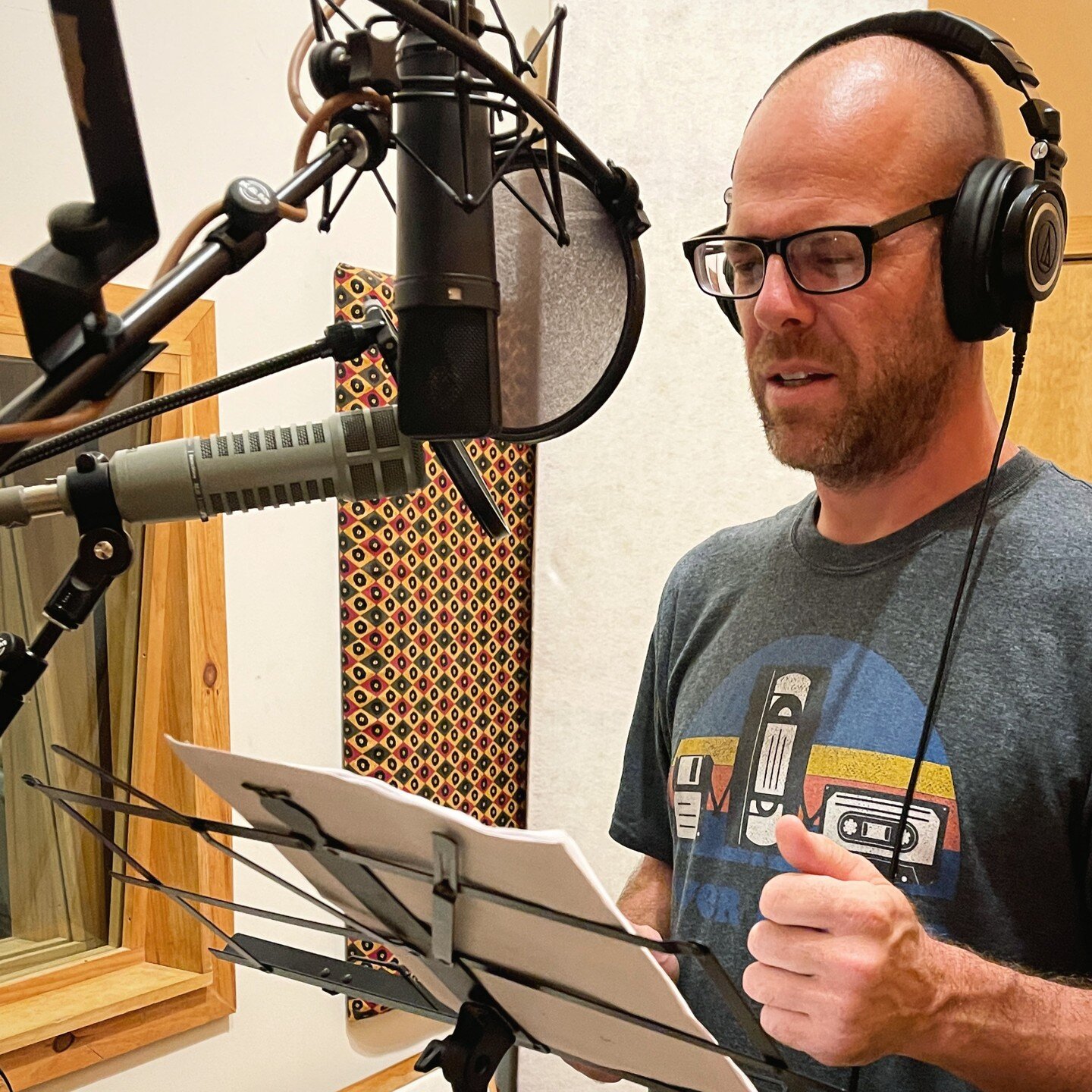 In addition to music, we do a lot of voice over recordings. Here's a photo of voice actor Nate Hackney in the isolation room recording a few spots. Wanna take a guess as to why there are two microphones here? Leave a comment below.