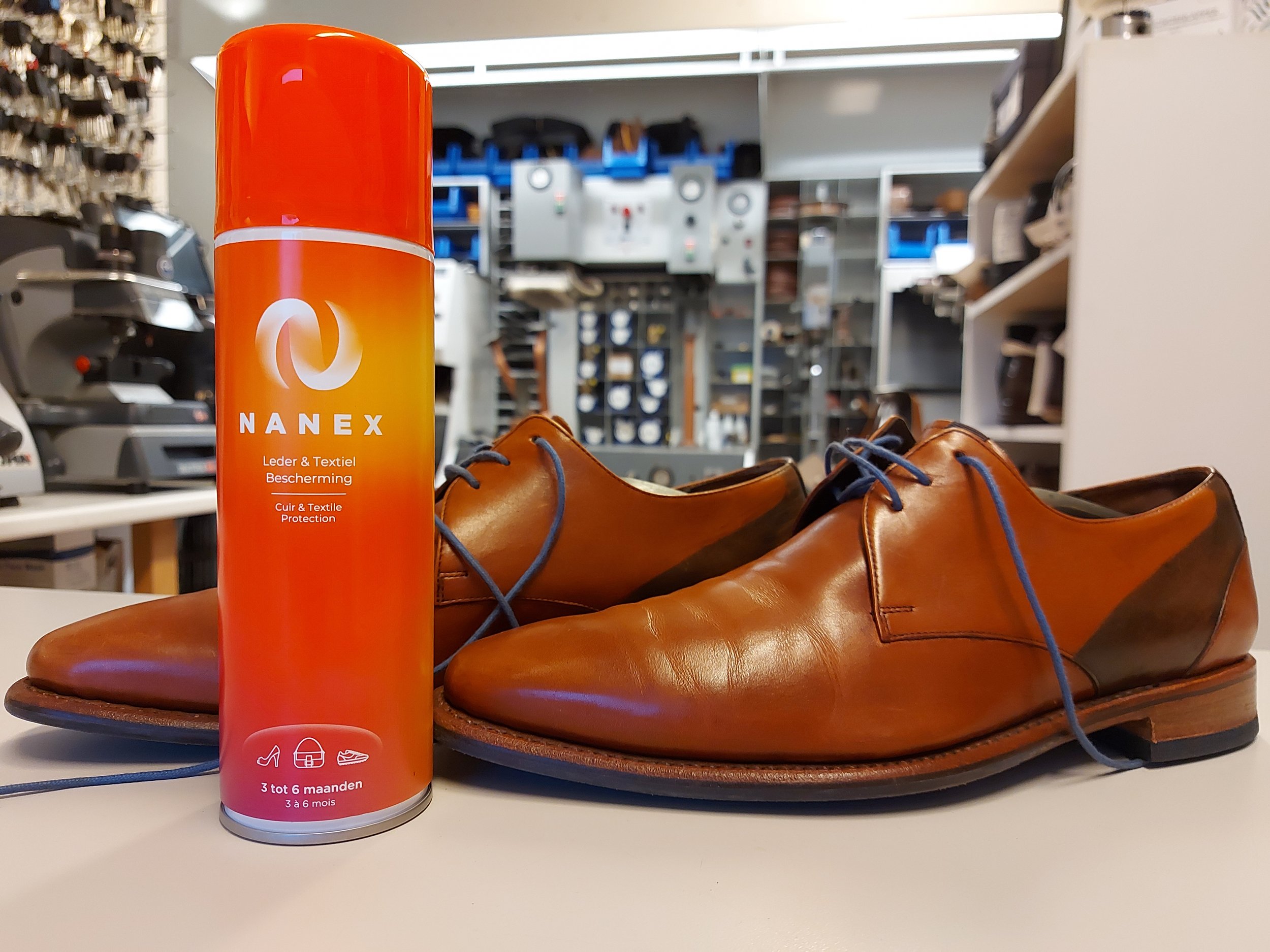 Leren schoenen met NANEX leder- en textielbeschermingsspray in een winkelomgeving.