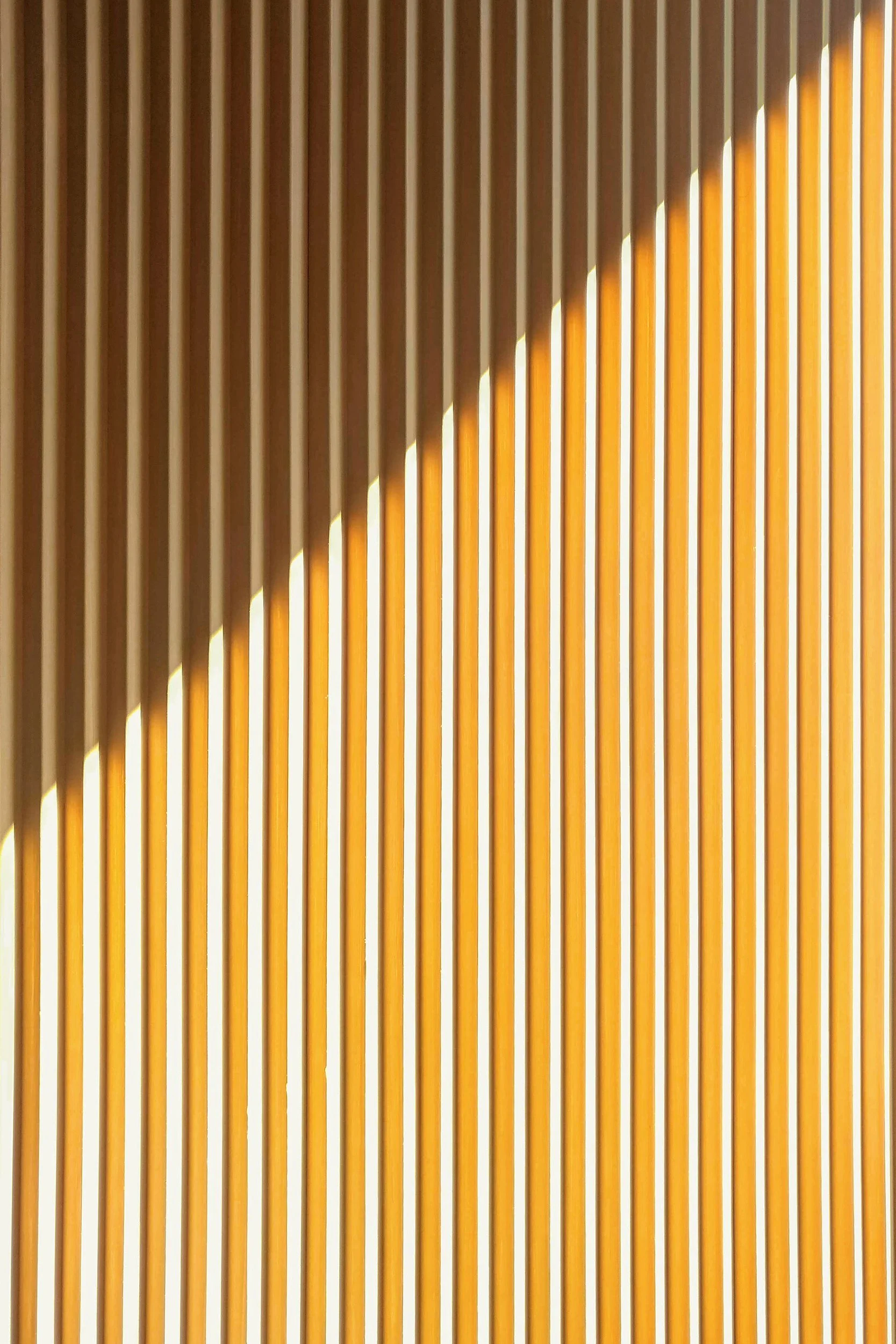 Vertical wooden slats with diagonal light and shadow pattern