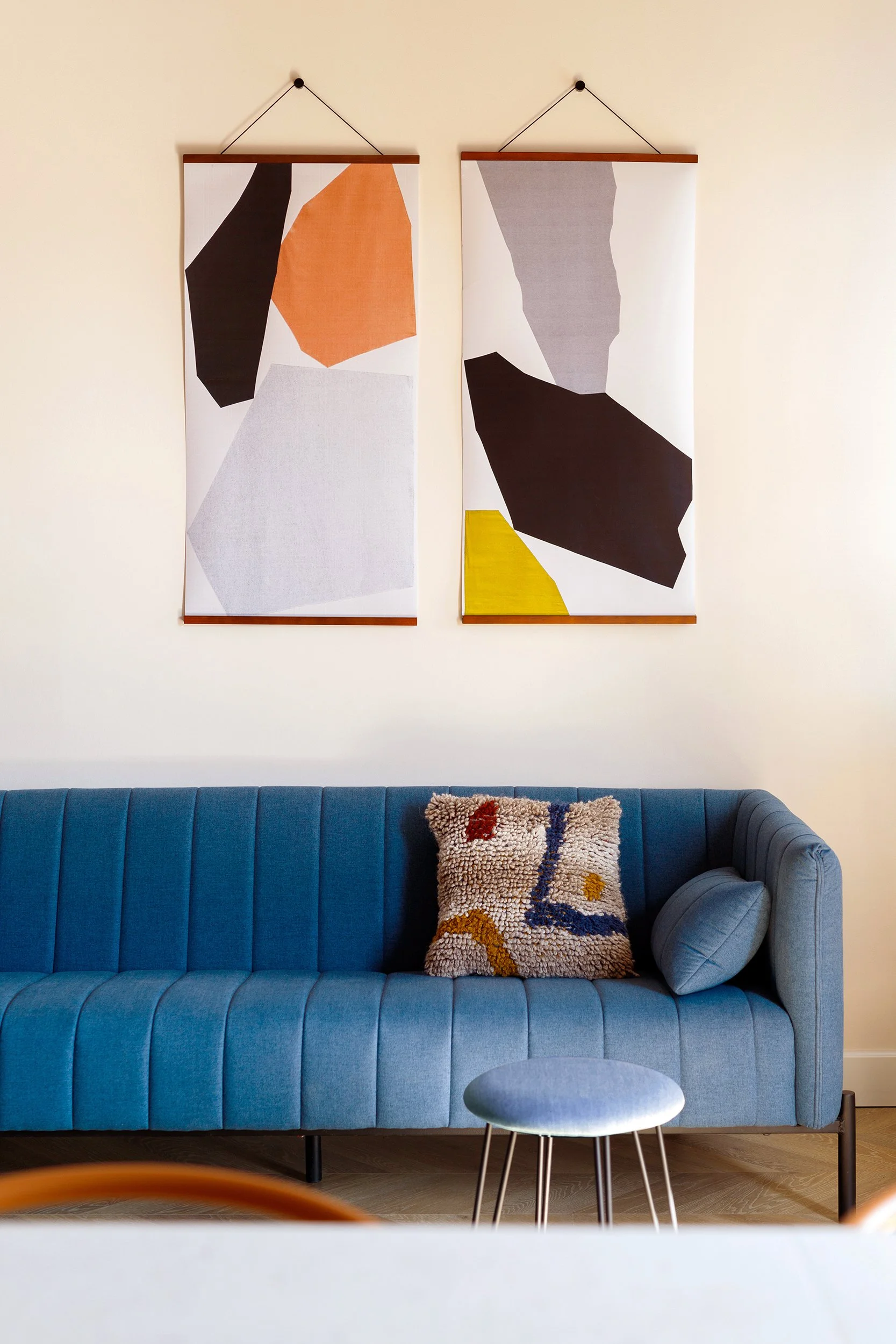 Modern living room with a blue sofa and abstract wall art
