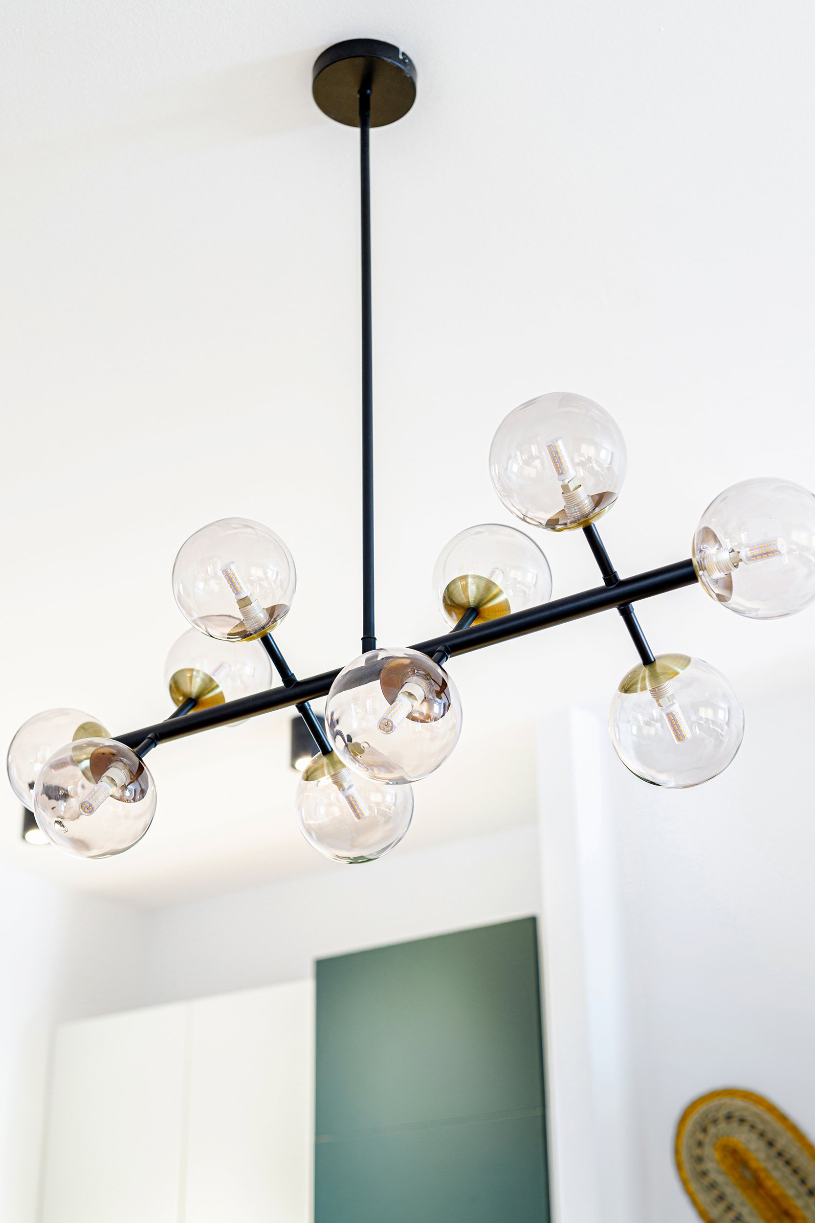 Modern chandelier with multiple glass globes and black metal frame.