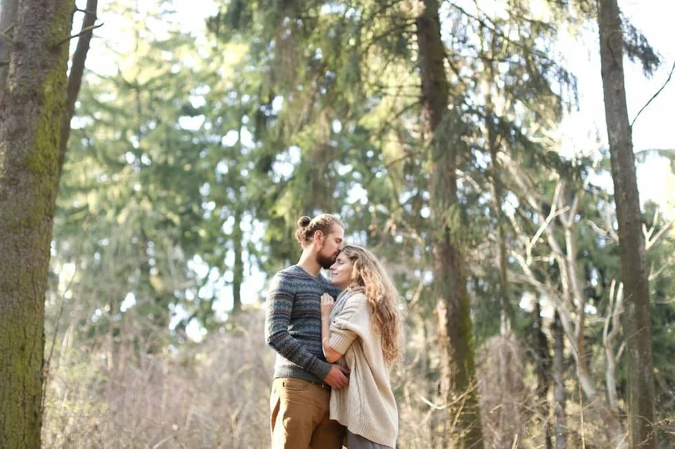 a-man-in-gray-sweater-kissing-a-woman-on-her-forehead