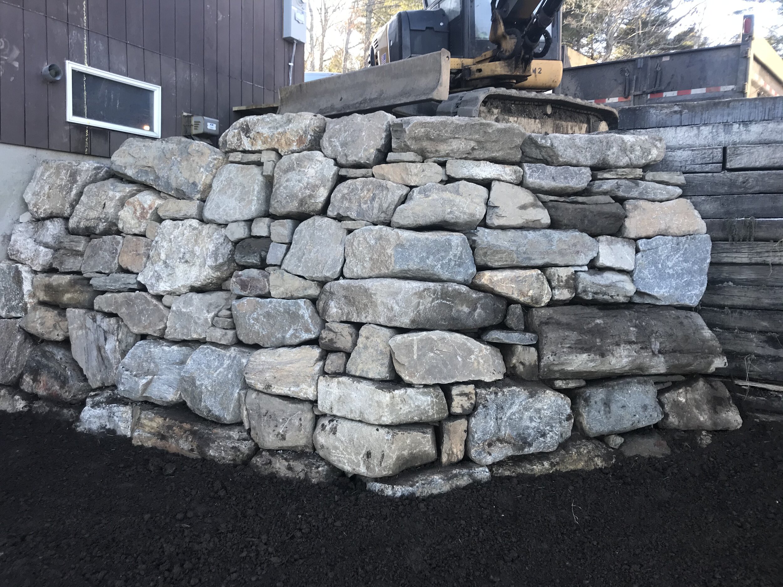 Dry laid boulder retaining wall, 8 ft tall