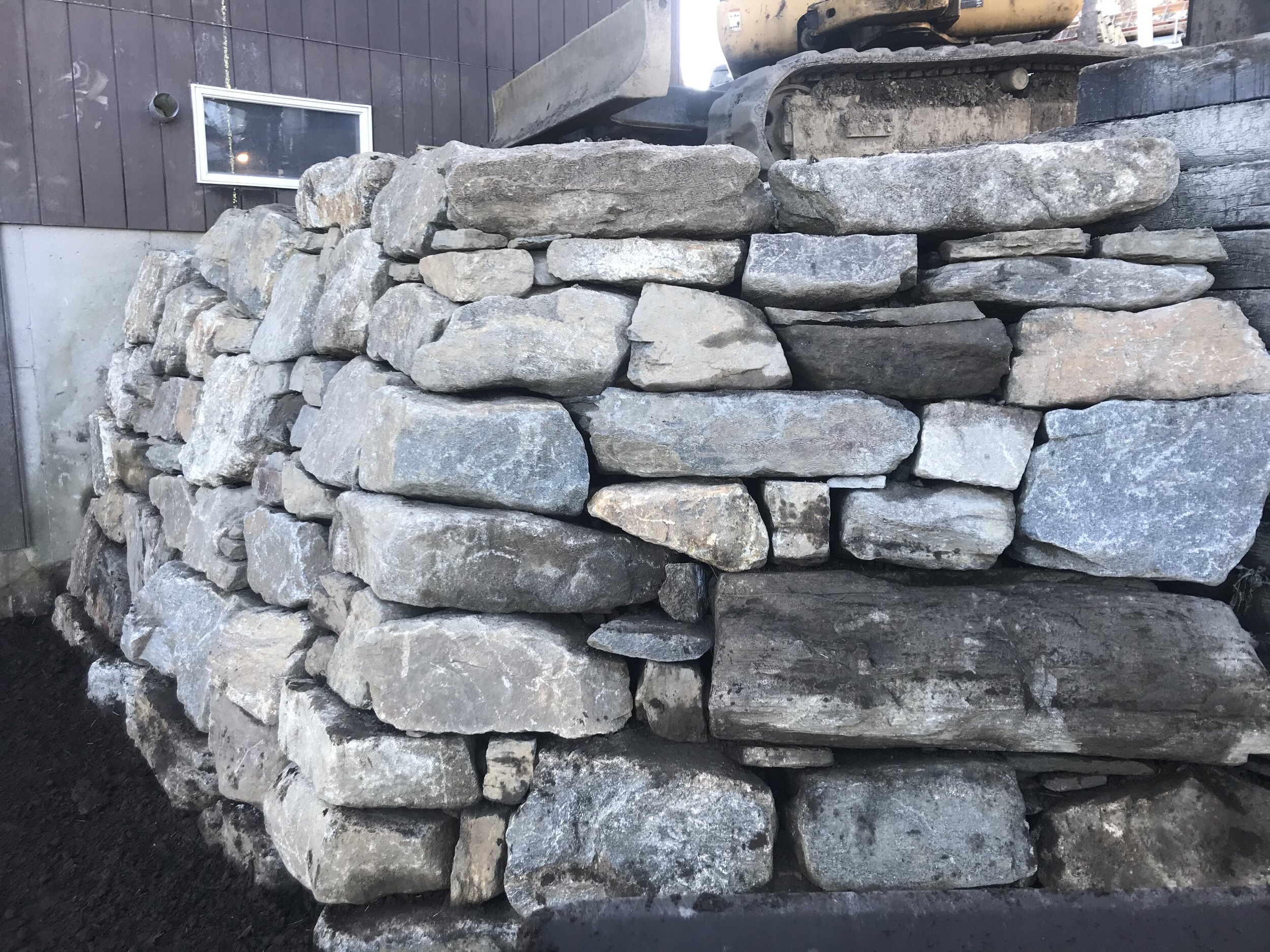 Dry laid boulder retaining wall, 8 ft tall