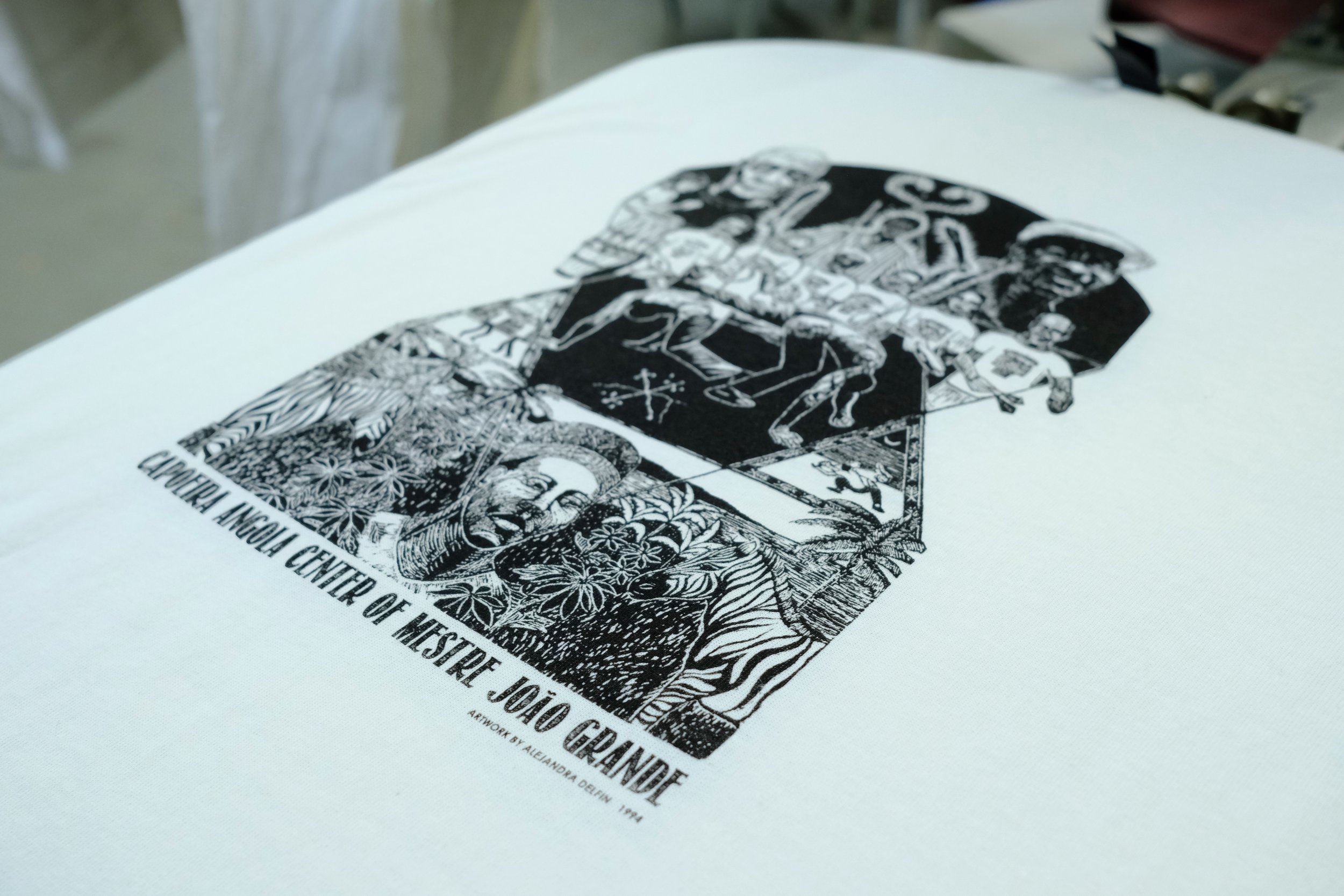 A black and white graphic poster featuring figures, animals, and decorative elements, with text indicating it is from the Cleveland Museum of Art, titled 'The Center of Westher, Joan Geismar, Alexandra Defrey, 1994.'
