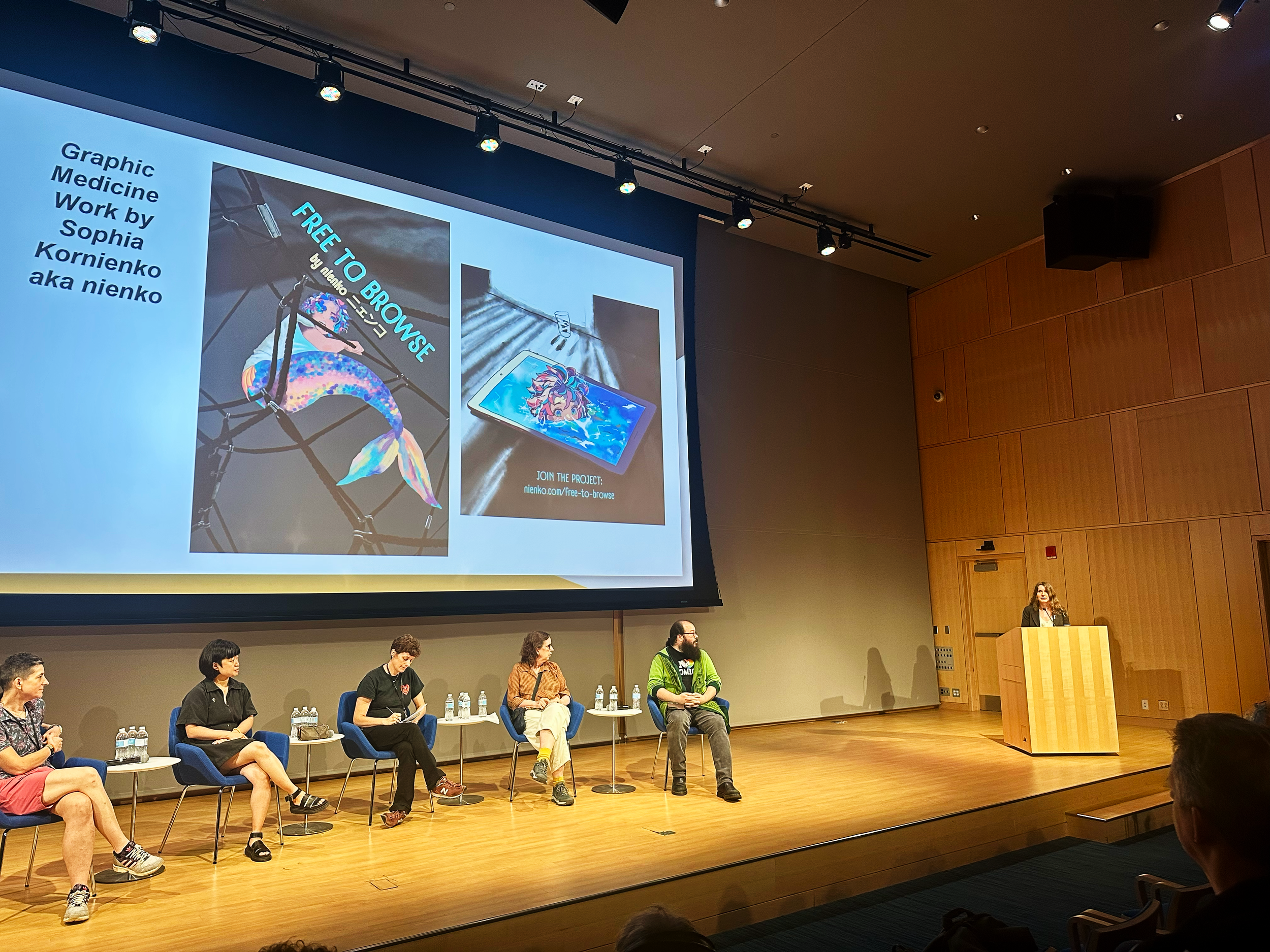 reading from Free To Browse at the National Cartoonists Society conference at the Boston Public Library in August 2025