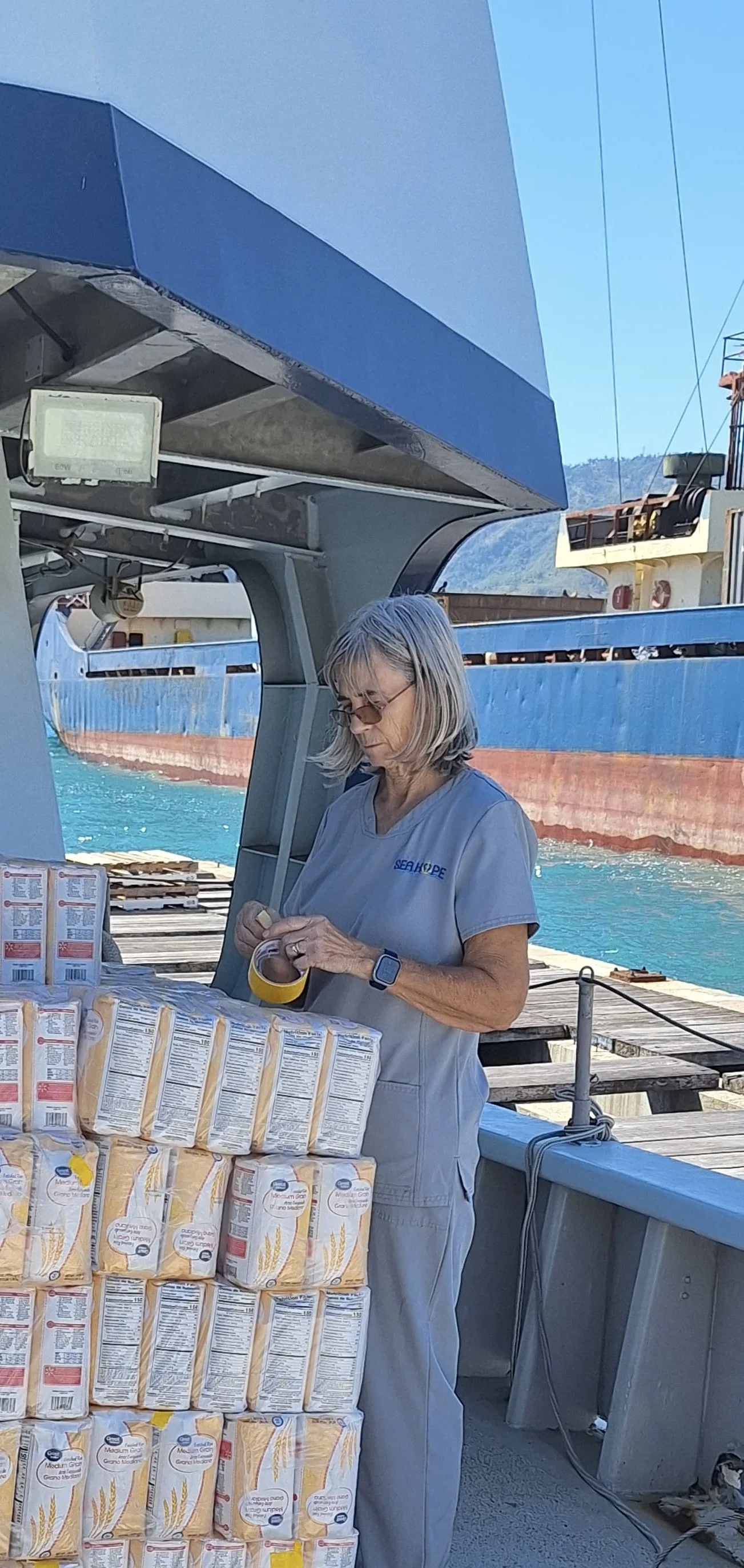 Mary did all the small jobs..Here she is taping up damaged bags of rice.  I might have been captain, but she made Sea Hope run...