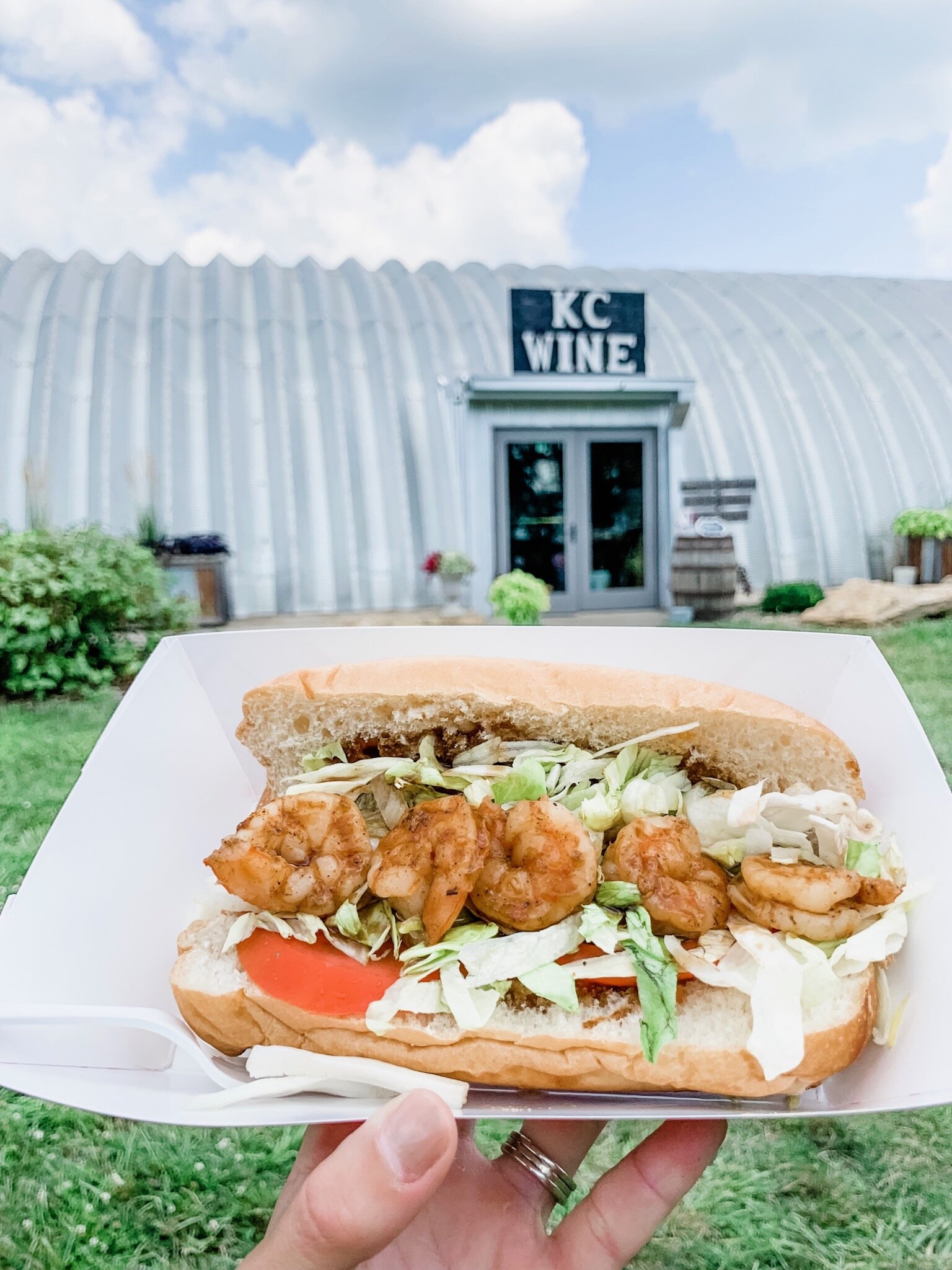A shrimp po boy sandwich in front of the KC Wines front door