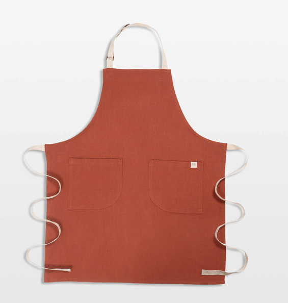 Burnt orange colored apron against a white background.