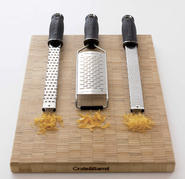 Three different microplanes balanced on a cutting board, illustrating the different sizes of grate.