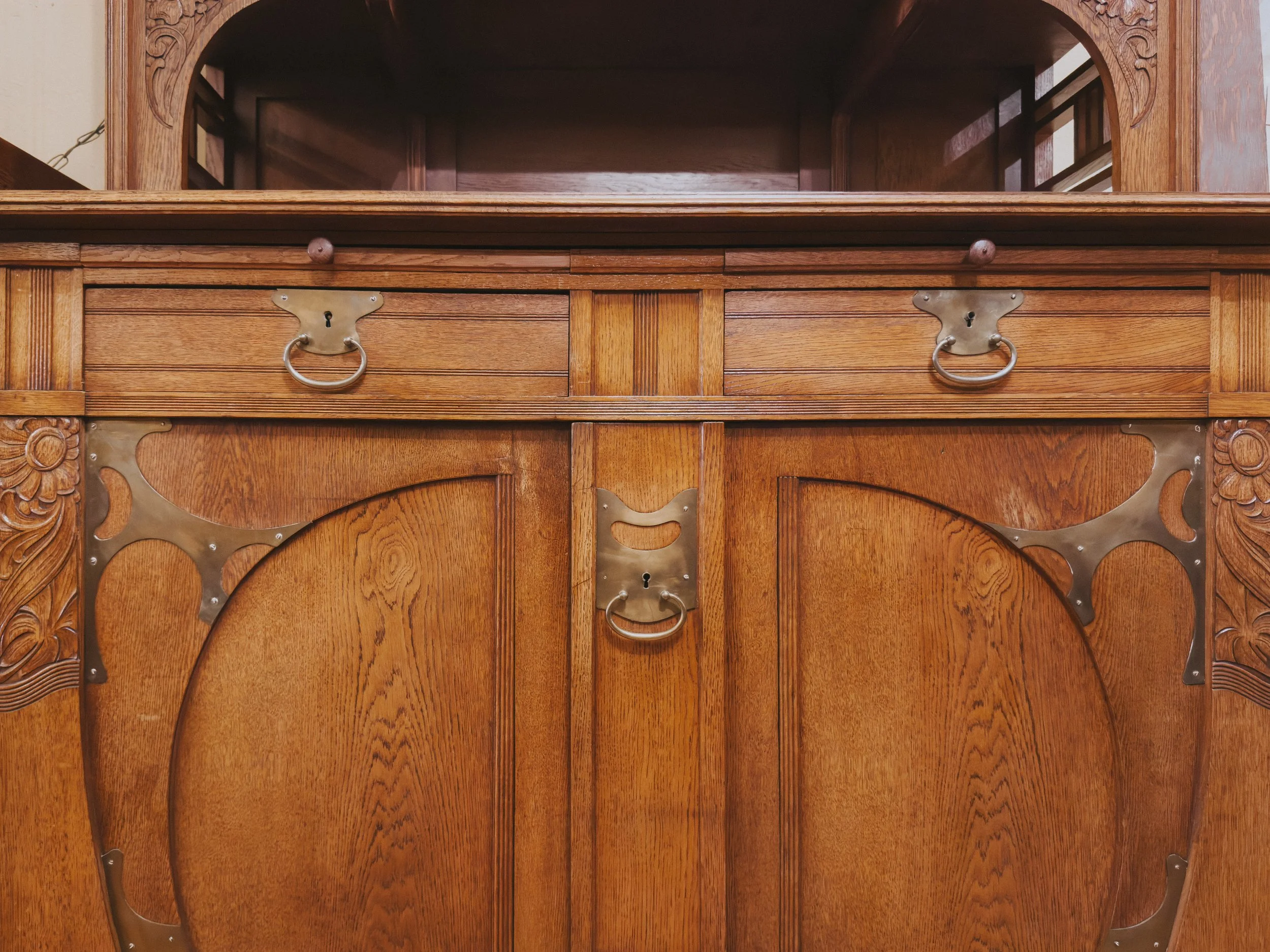 Polished brass hardware on an art nouveau buffet